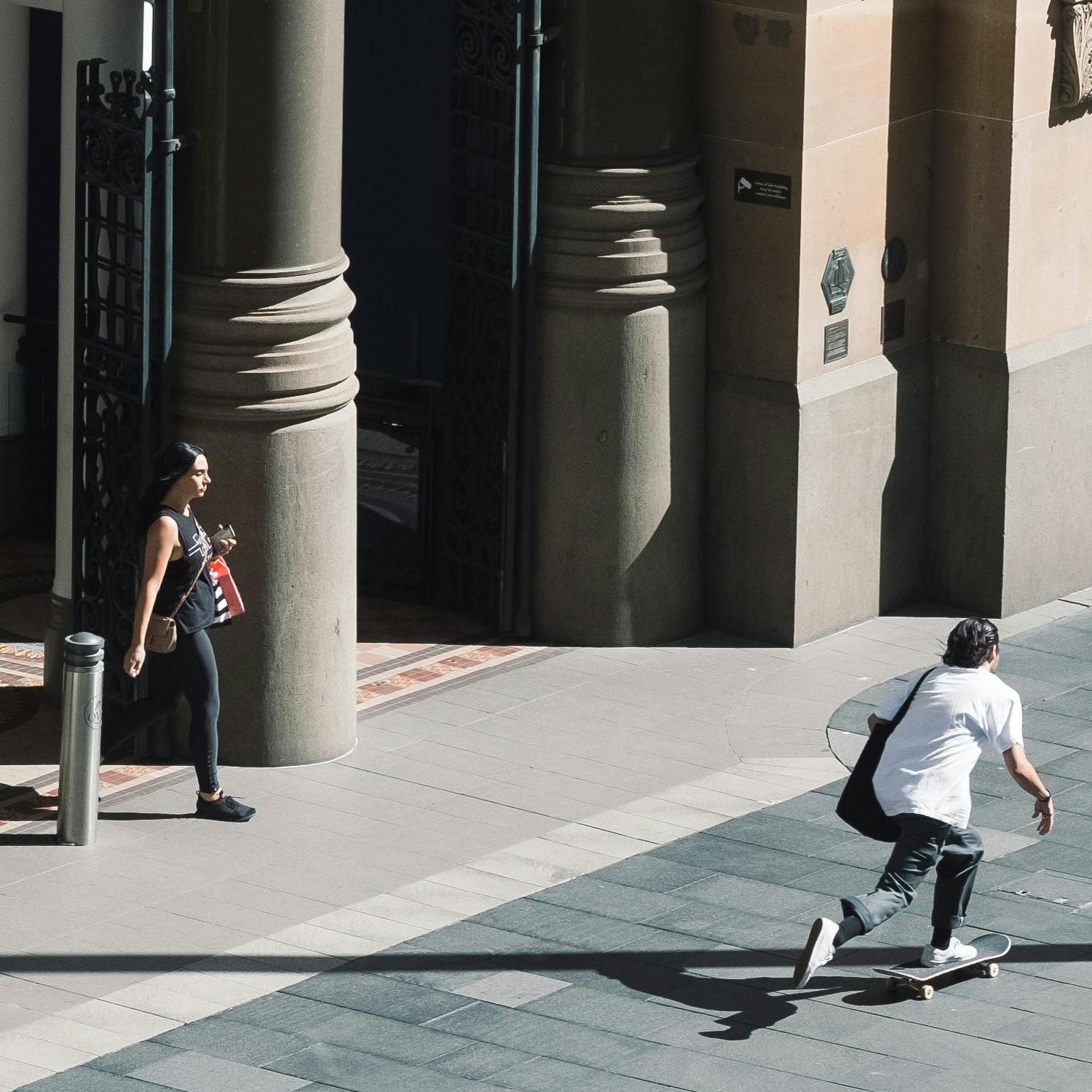 A man on a skateboard passing by QVB in Sydney