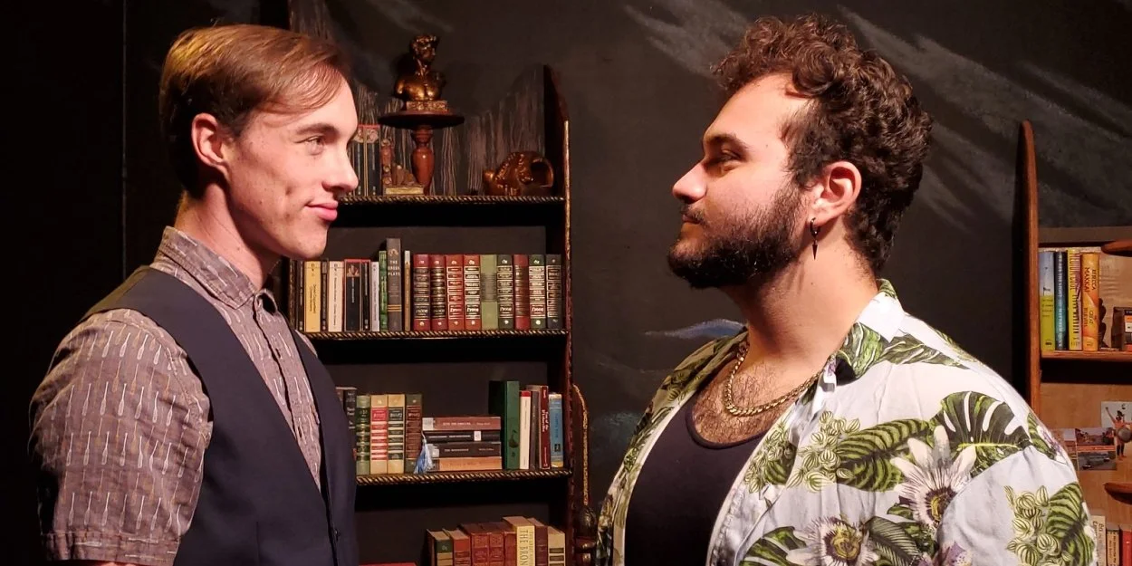 Two men facing each other in confrontation, standing close indoors with bookshelves in the background.