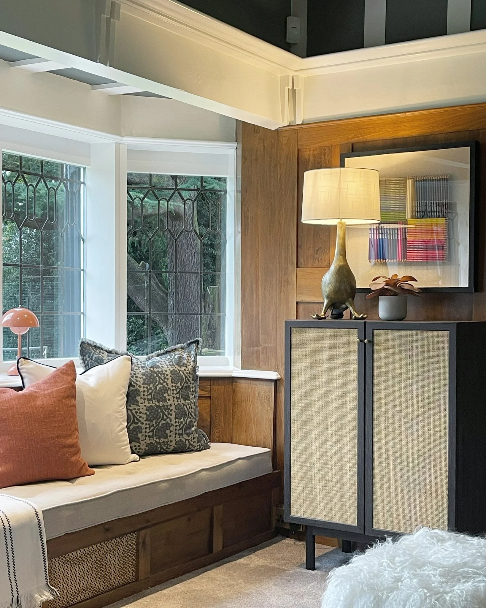 Bespoke nook with upholstered window seating, dark cabinetry and warm timber panelling in a Grade II listed property.