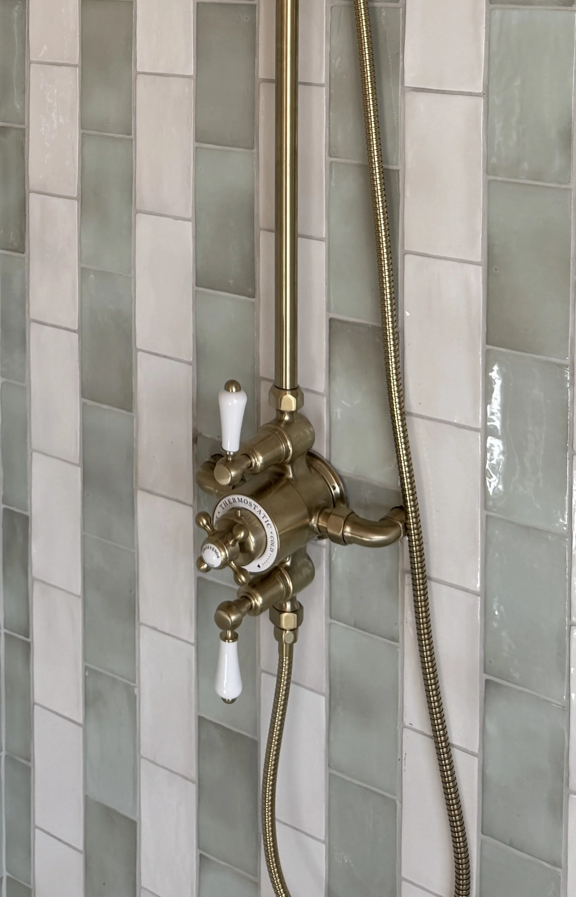 Solid brass bathroom fittings paired with handcrafted glazed tiles to create a timeless and elegant bathroom scheme.