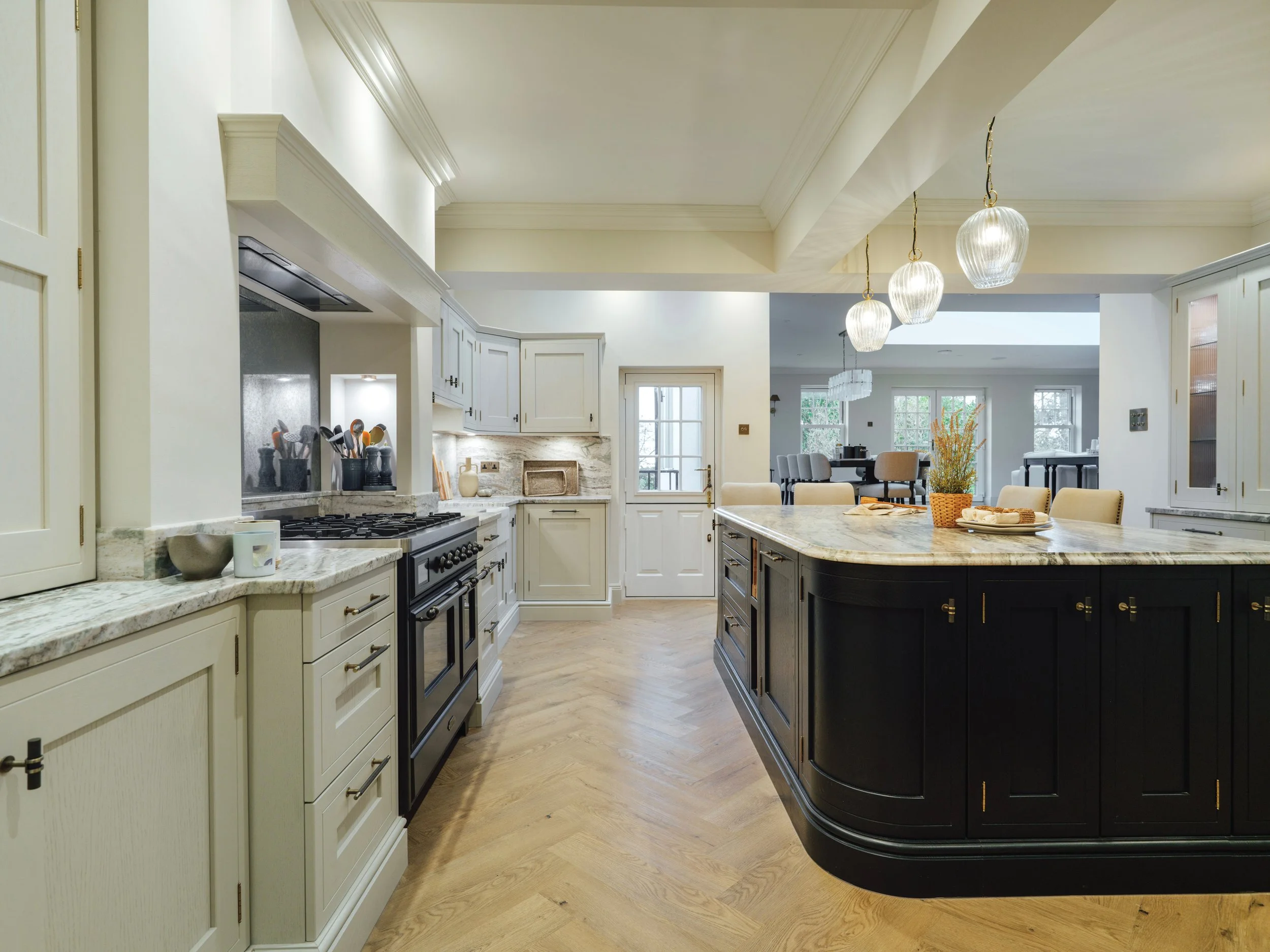 View across the bespoke shaker kitchen with black island, vaulted ceiling and marble worktops at Project Orton.