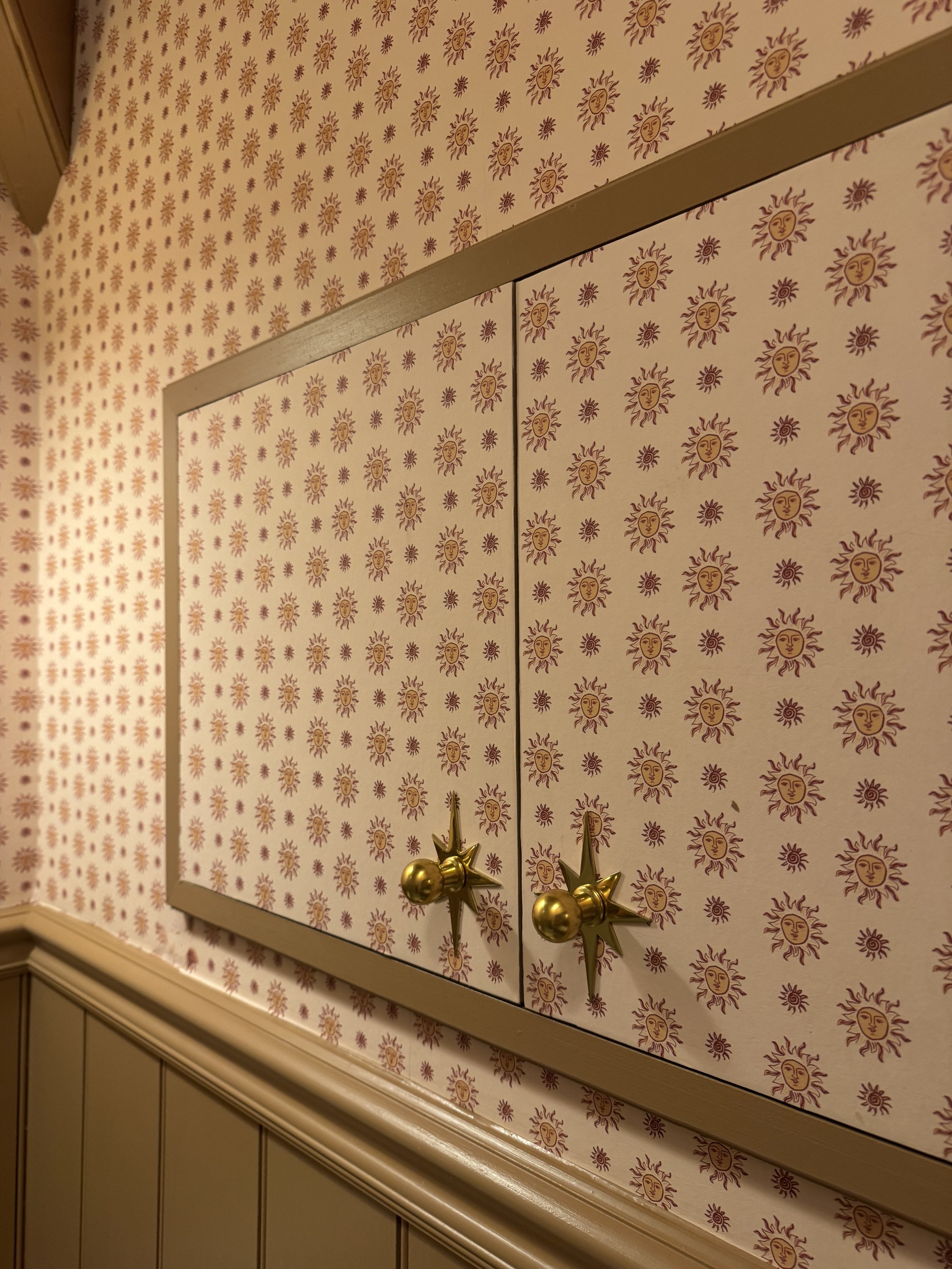 Ensuite with decorative wallpaper, concealed storage and painted tongue and groove panelling.