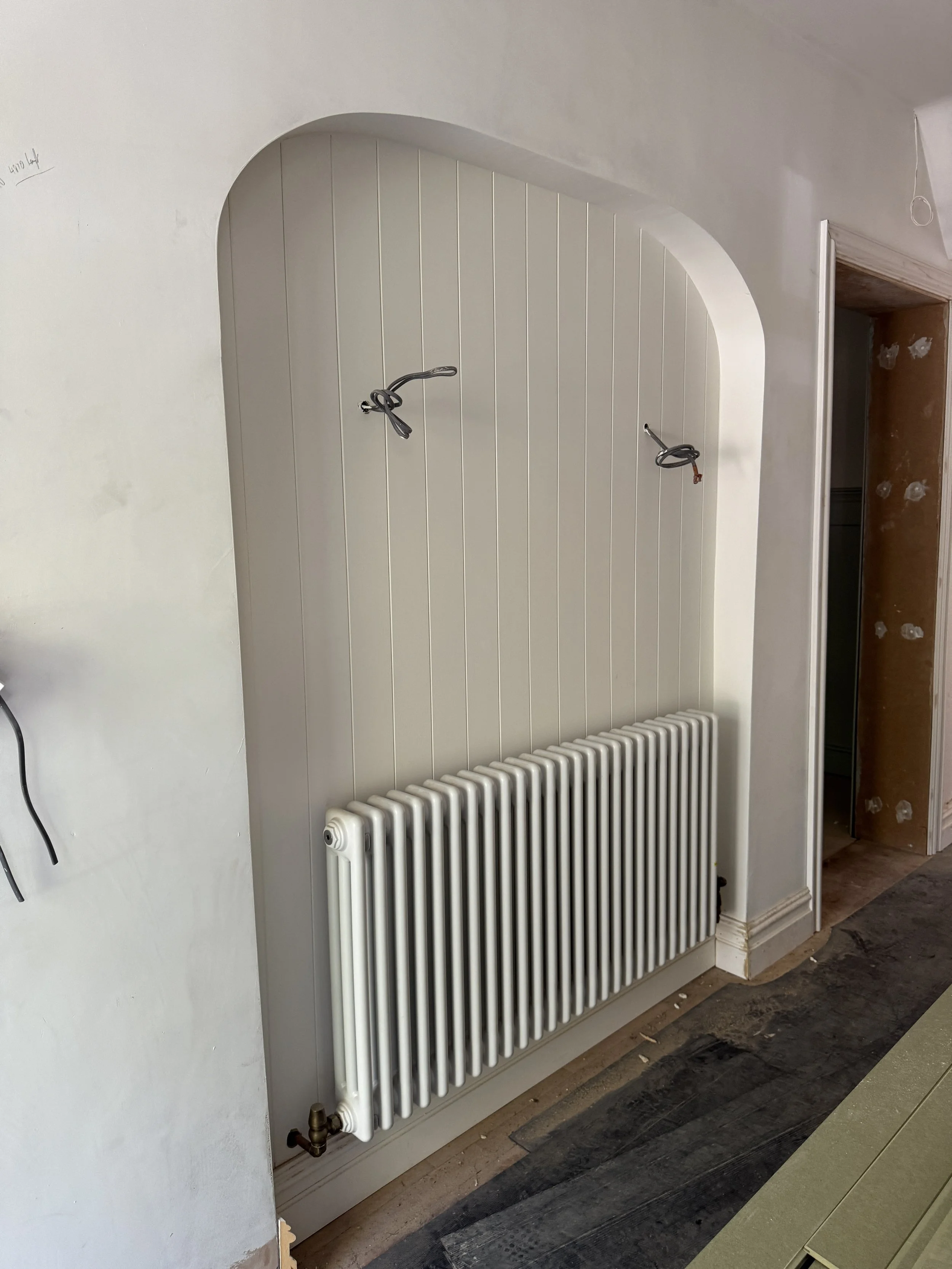 Bespoke arched radiator alcove adding traditional character while integrating practical architectural detailing.