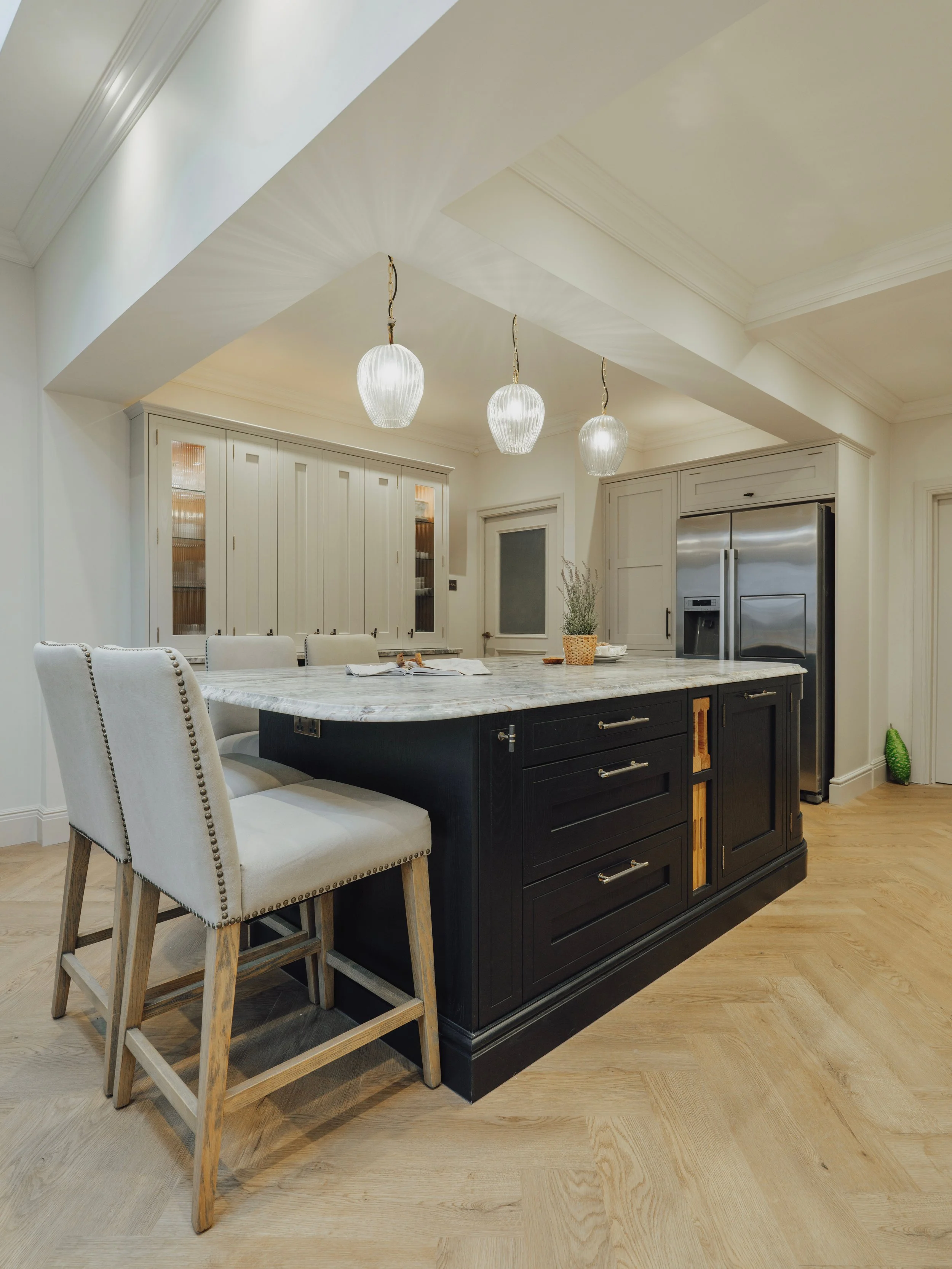 Timeless family kitchen with a navy shaker island, granite worktops and coffered ceiling, designed for modern family living.