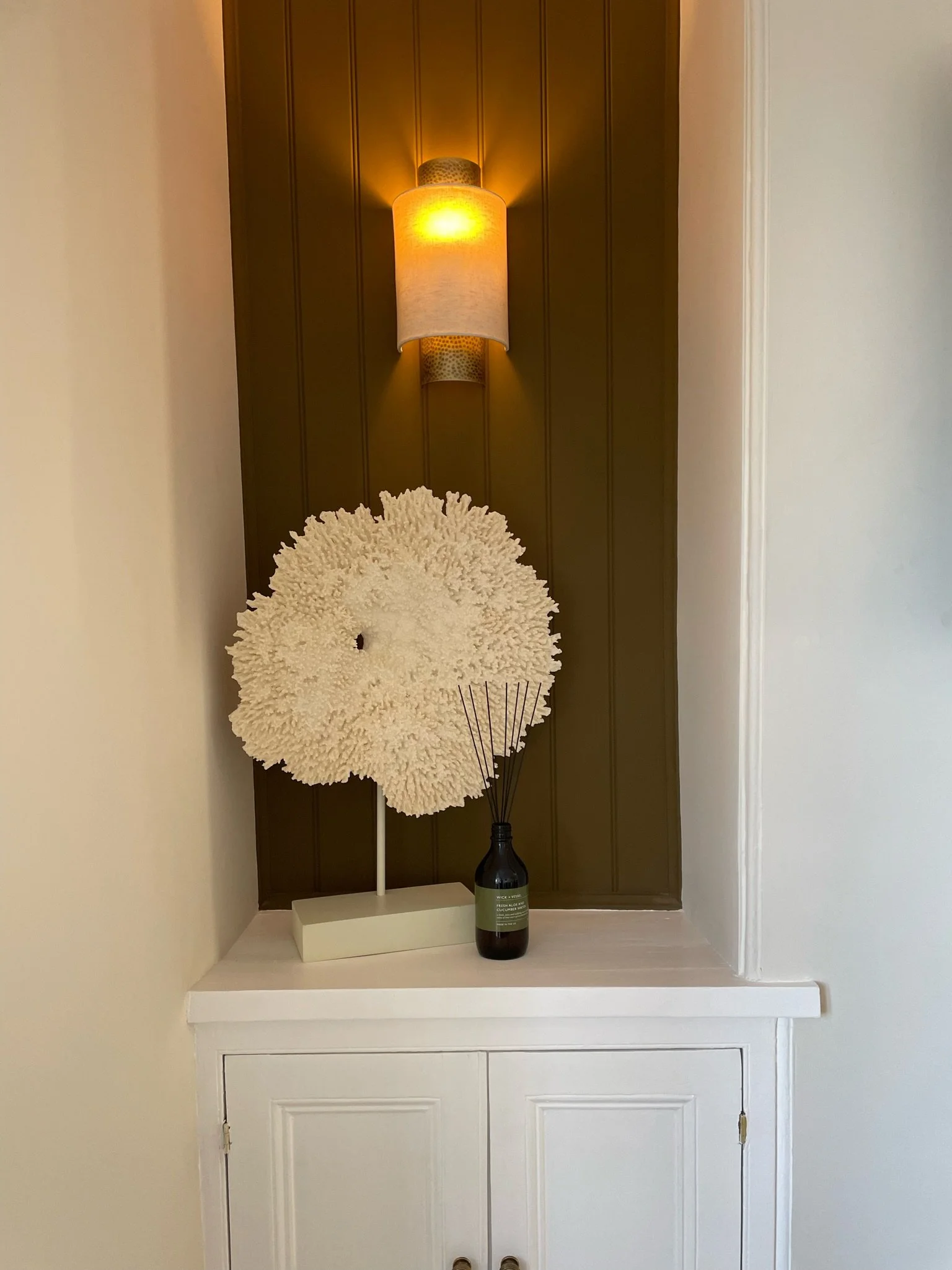 Decorative panelled alcove in Project Brixham, Devon, featuring layered styling, warm lighting and coastal-inspired accessories.