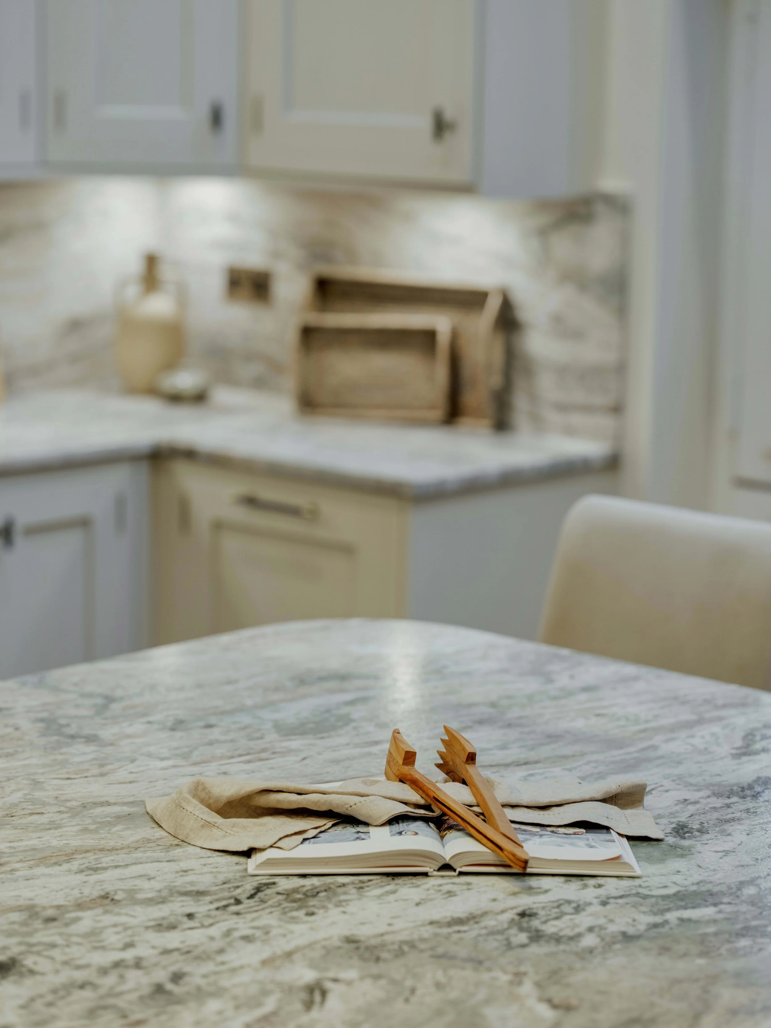 Marble kitchen island styled with natural linens and wooden serving utensils at Project Orton.