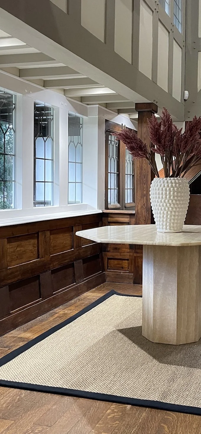 Original timber panelling and bespoke stone table detail within the entrance hall of a Grade II listed home.