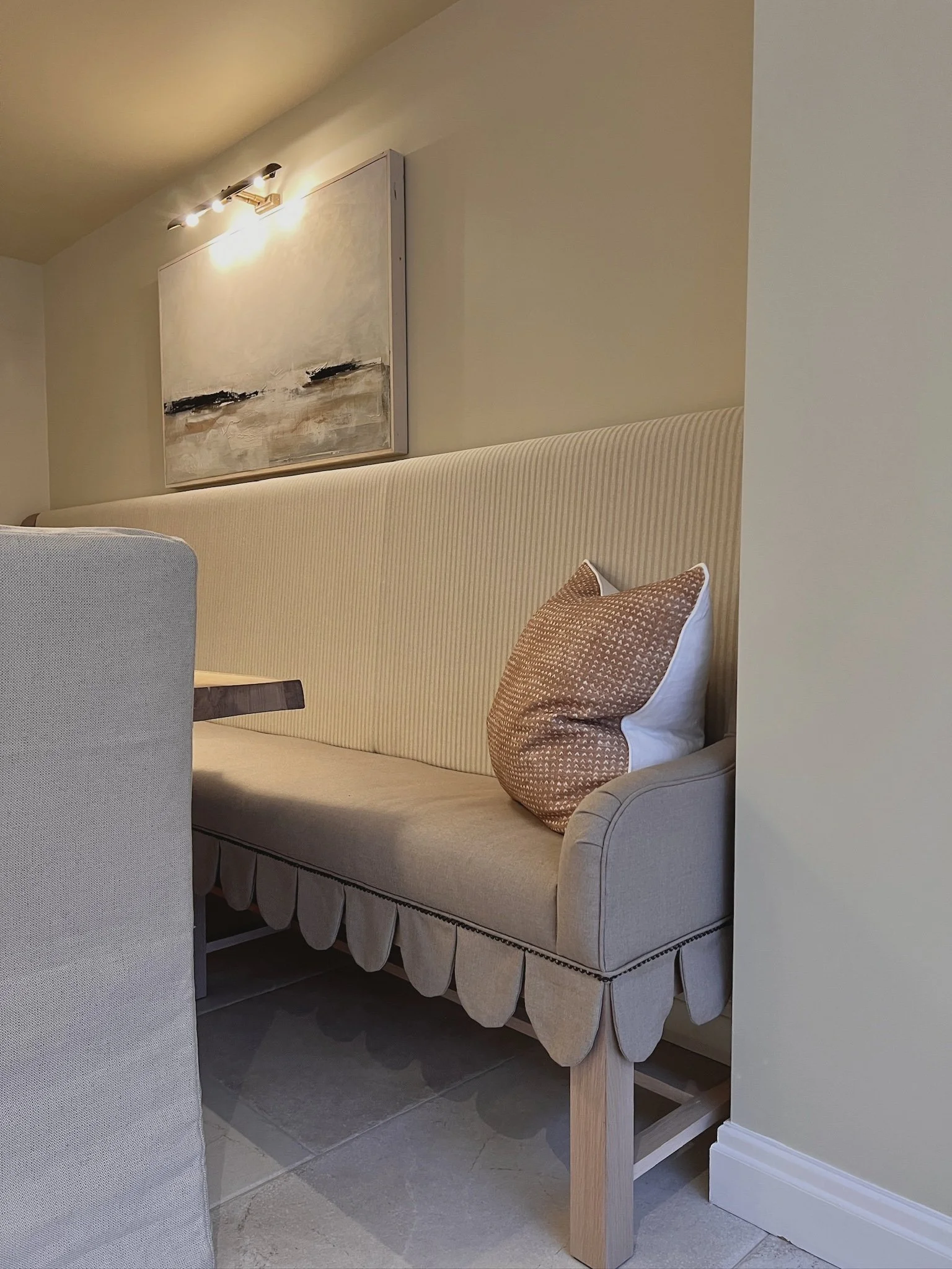 Close-up of bespoke banquette seating with soft neutral upholstery and layered textures.