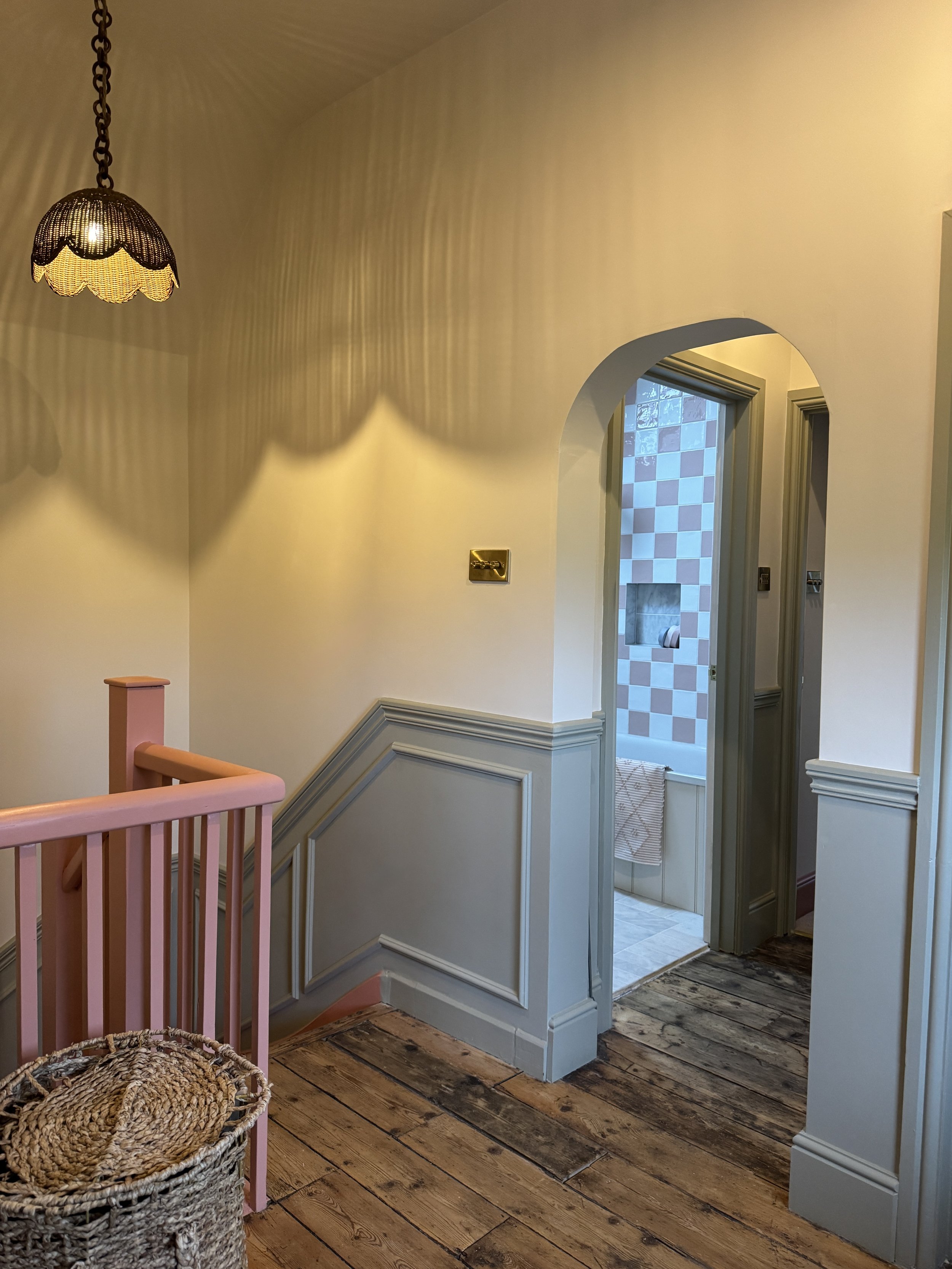 Traditional first floor landing with painted wall panelling, original timber floorboards and decorative lighting.