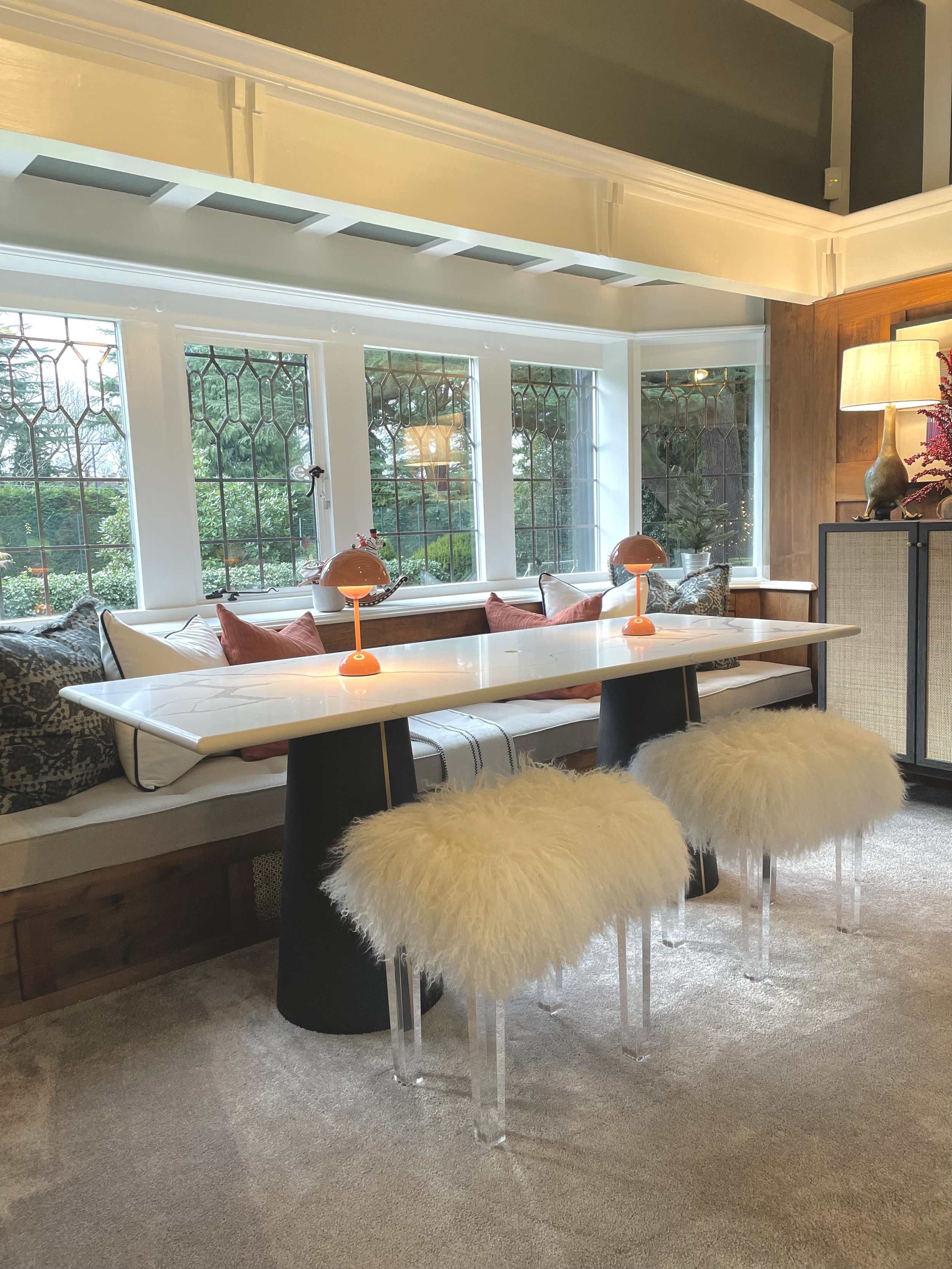 Contemporary playroom with bespoke window seating, marble table and original leaded windows within a heritage family home.