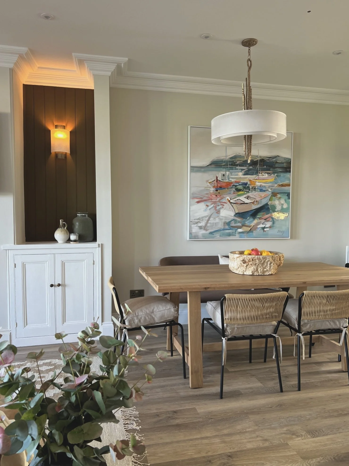 Dining room in Project Brixham, Devon, featuring a solid oak dining table, coastal artwork and natural textures.