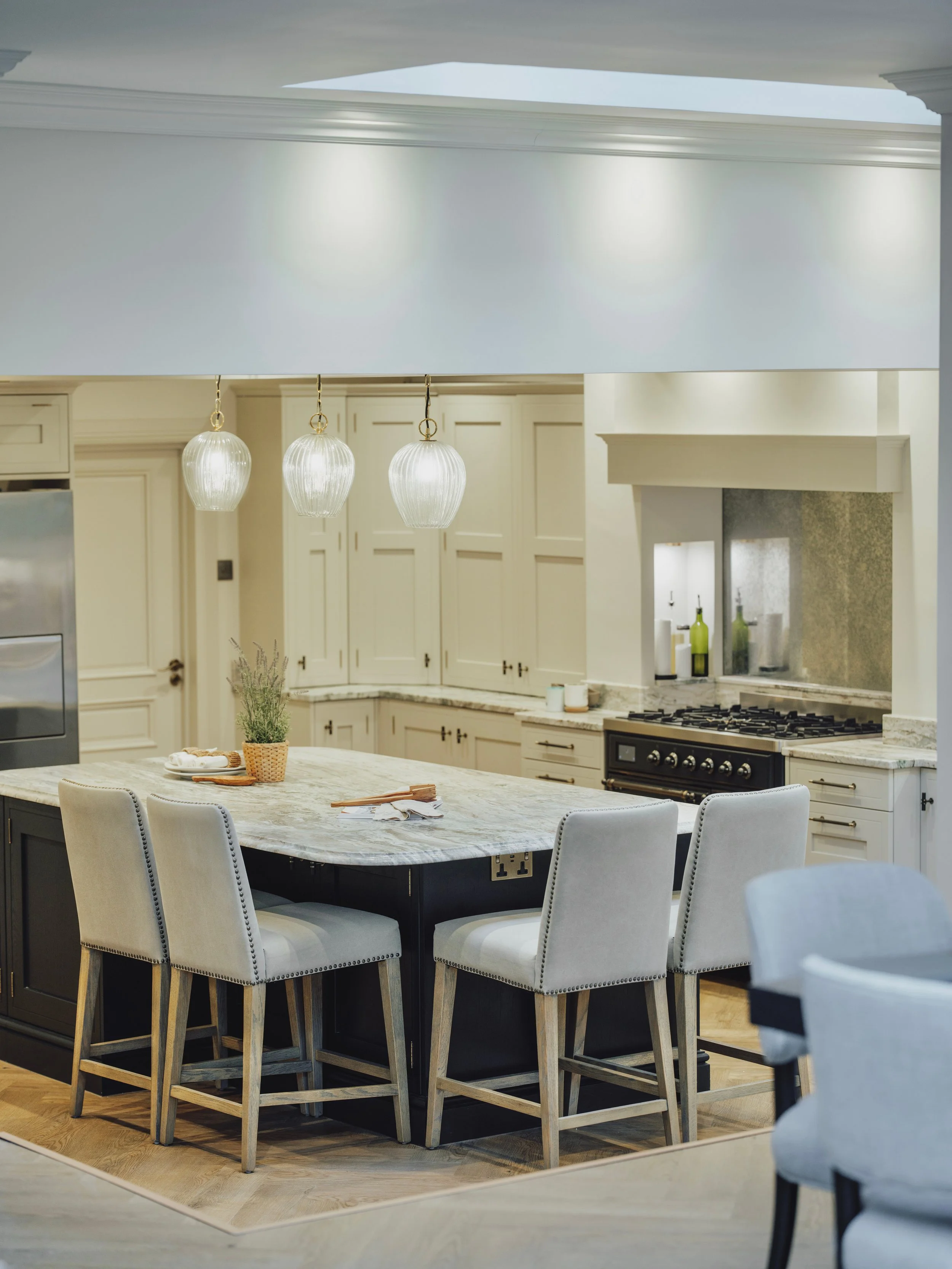 View across the bespoke shaker kitchen with black island, coffered ceiling and granite worktops at Project Orton.