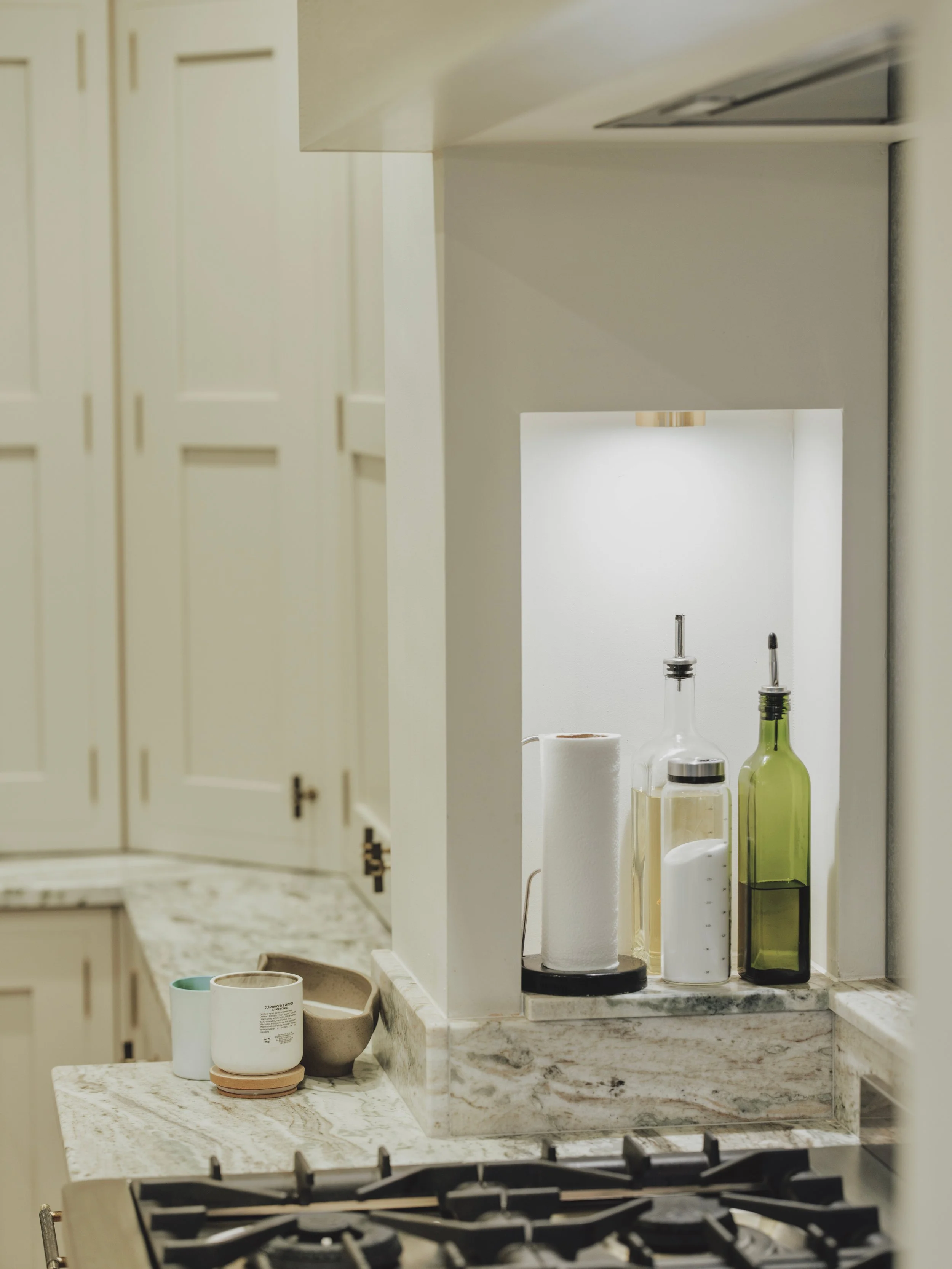 Illuminated kitchen niche with marble shelving and traditional shaker cabinetry at Project Orton.