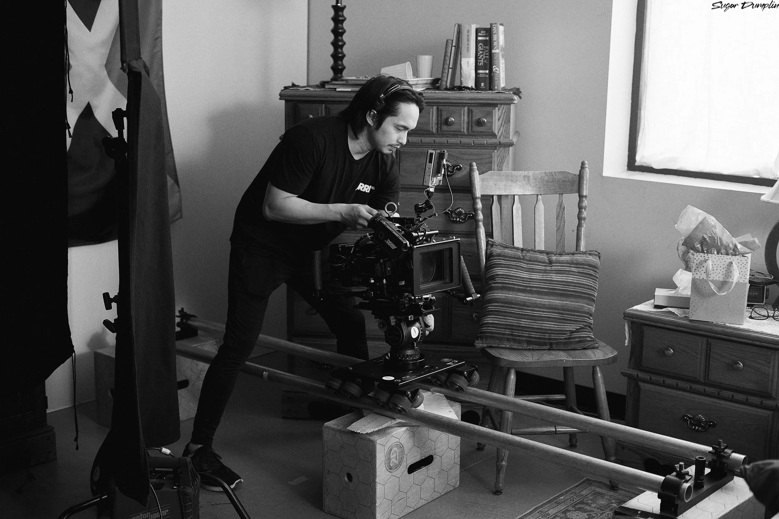 Shot of director of photography Angel Navarro the third as he gears up to capture another beautiful scene of short film Sugar Dumplin', directed by Tristan Barrocks. 
