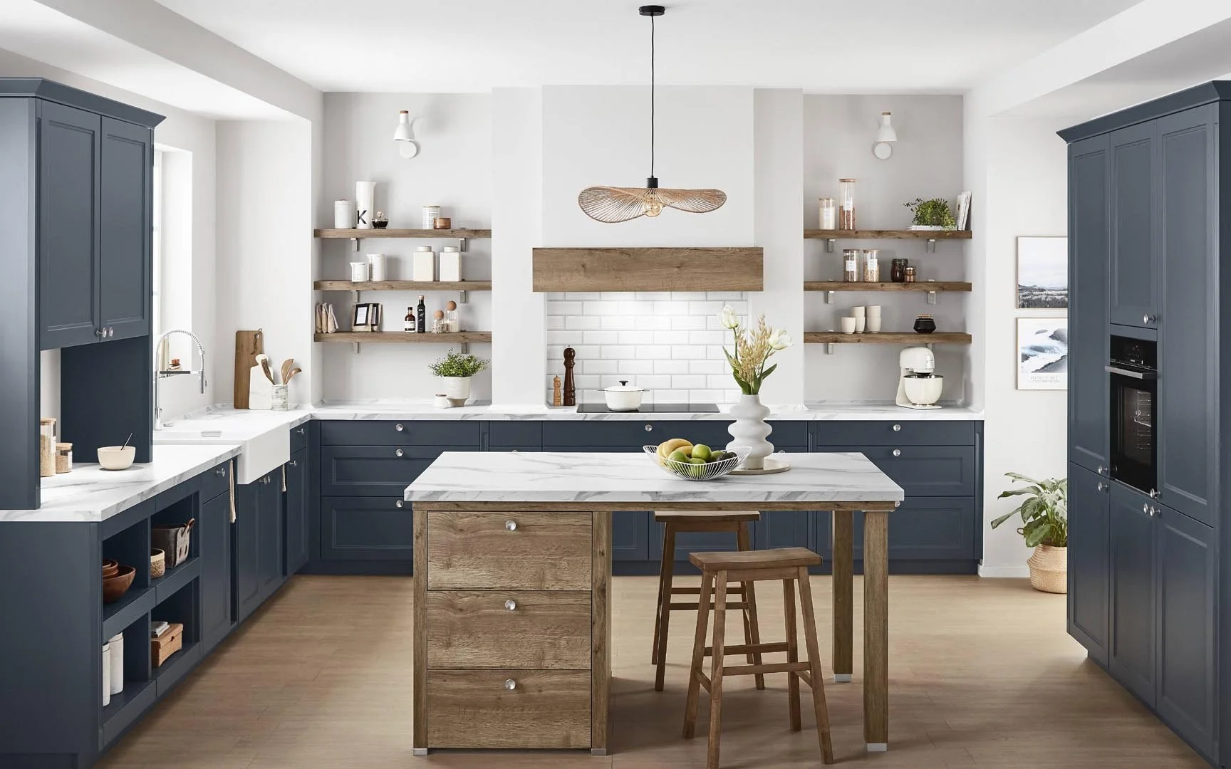 Modern kitchen with navy blue cabinets, white marble countertops, open wooden shelves, and a kitchen island with a marble top