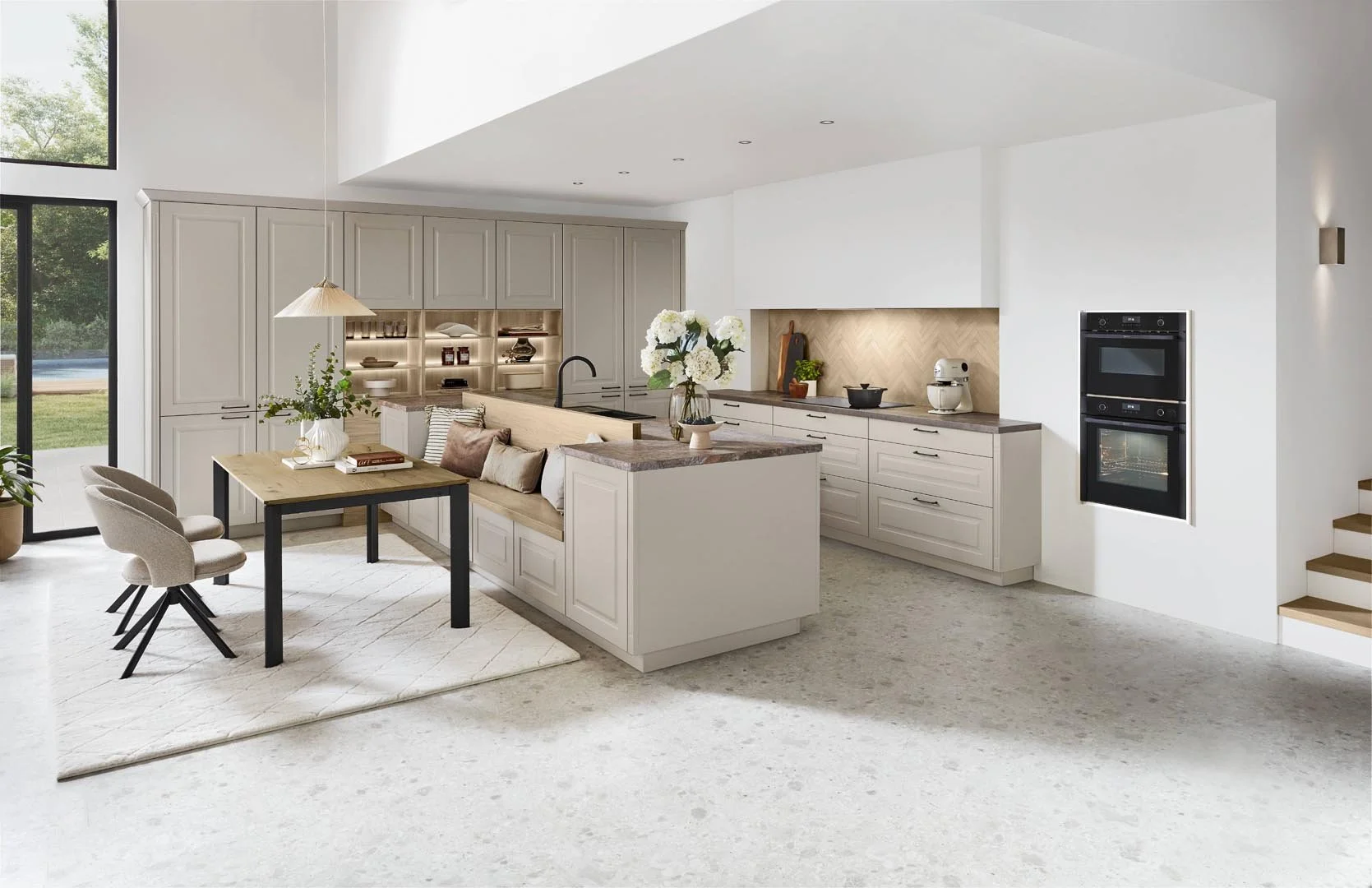 Modern kitchen with white cabinetry, beige accents, wooden countertops, a dining table with chairs, and built-in double oven.