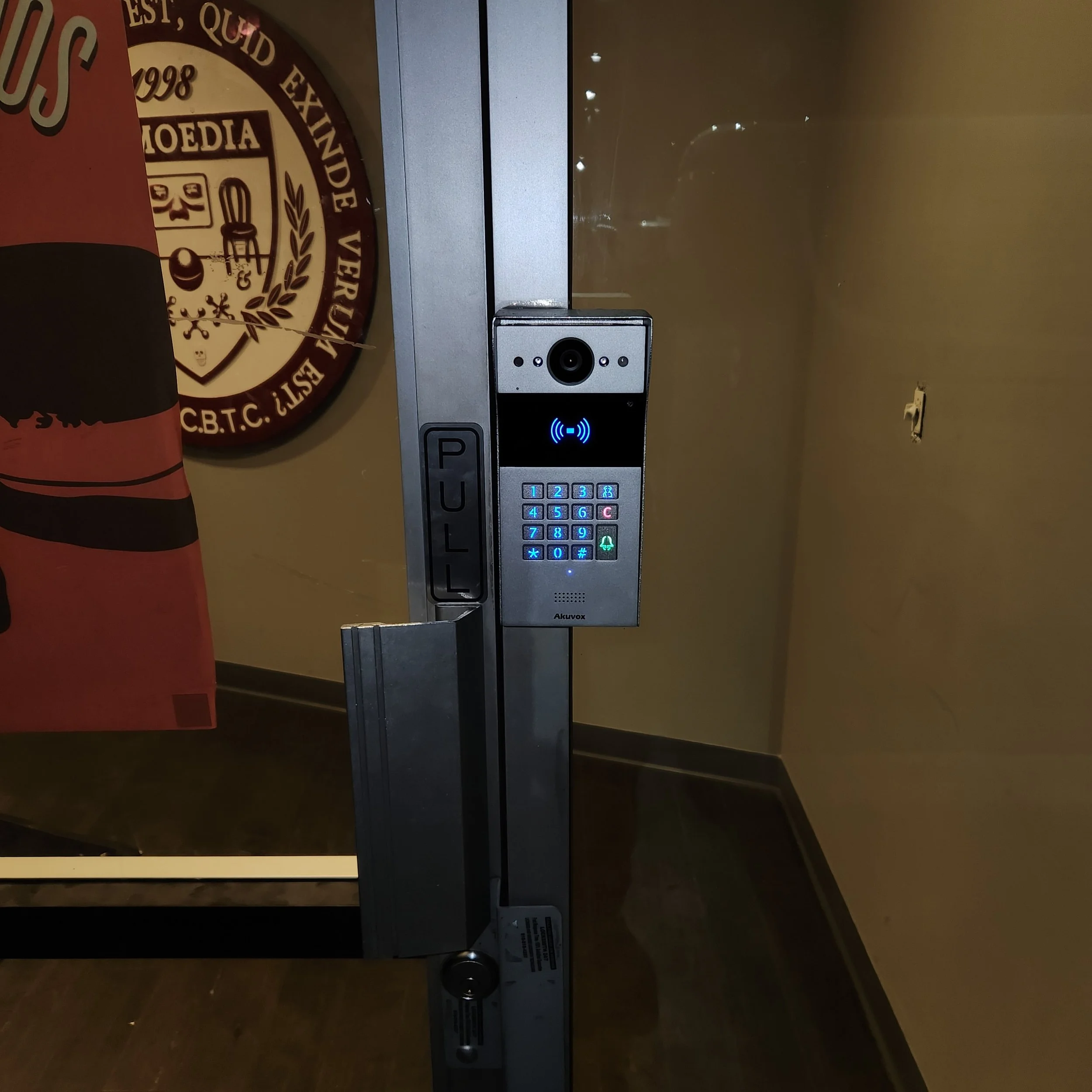 Access control system at a university in Los Angeles. Image shows door, access control panel, and university logo visible in background through glass door