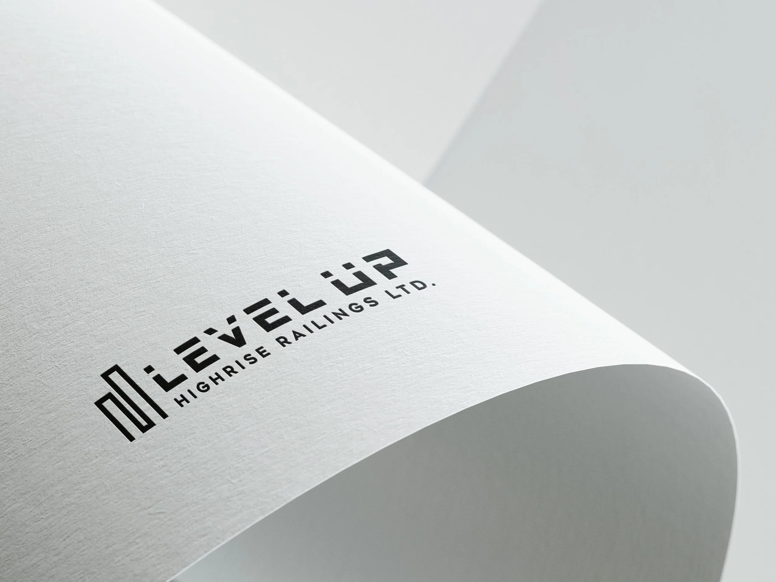 Close-up of printed text on white paper sheet, displaying 'LEVEL UP HIGHRISE RAILINGS LTD.' in bold, modern font.
