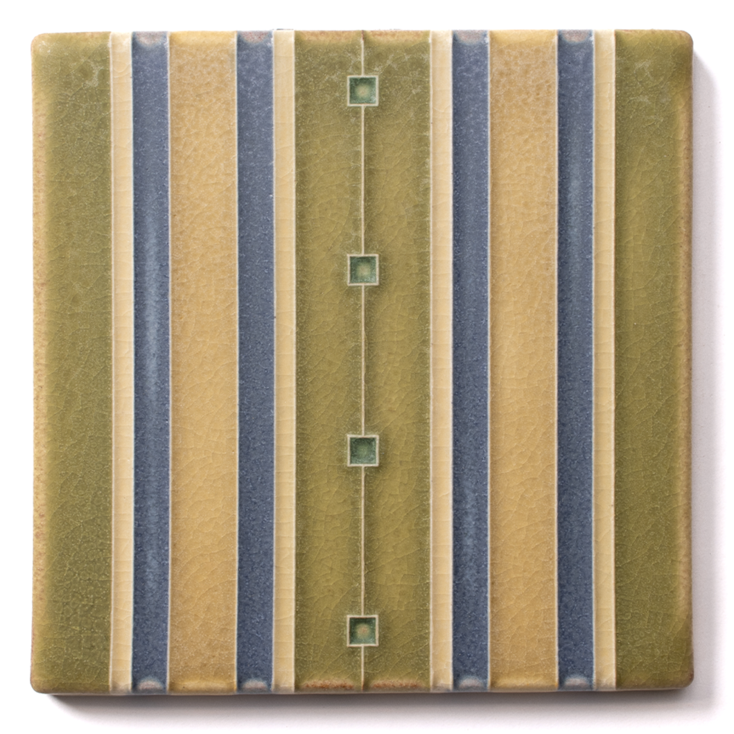 A vintage ceramic tile with a geometric pattern of vertical stripes in shades of green, blue, and cream, featuring small square accents along a central line.