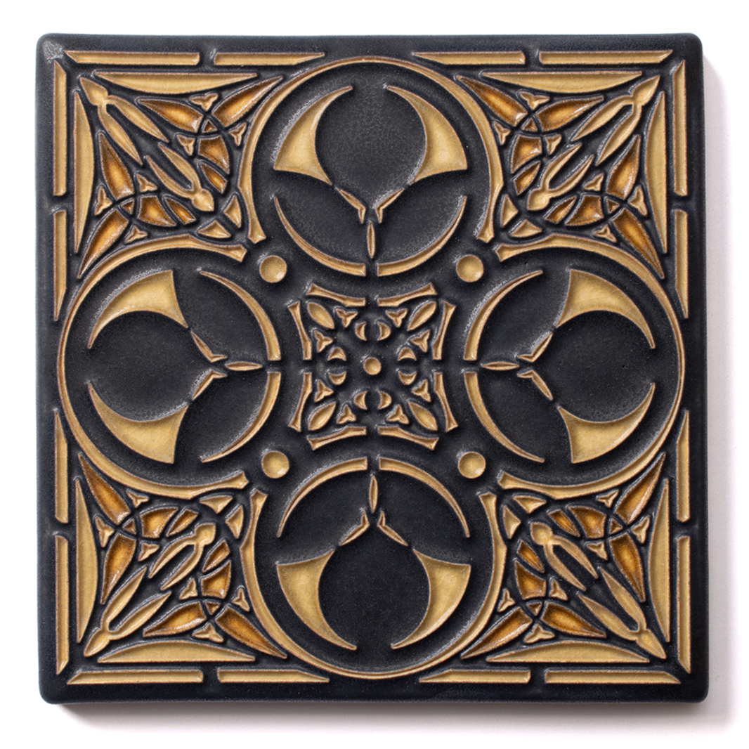 Black decorative tile with gold geometric and floral patterns, featuring crescent shapes, circles, and intricate cutouts.