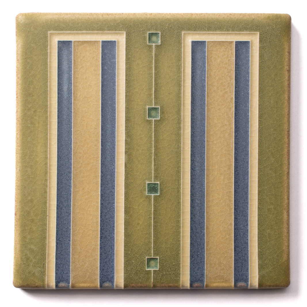 A decorative ceramic tile with geometric patterns in shades of yellow, green, and blue.