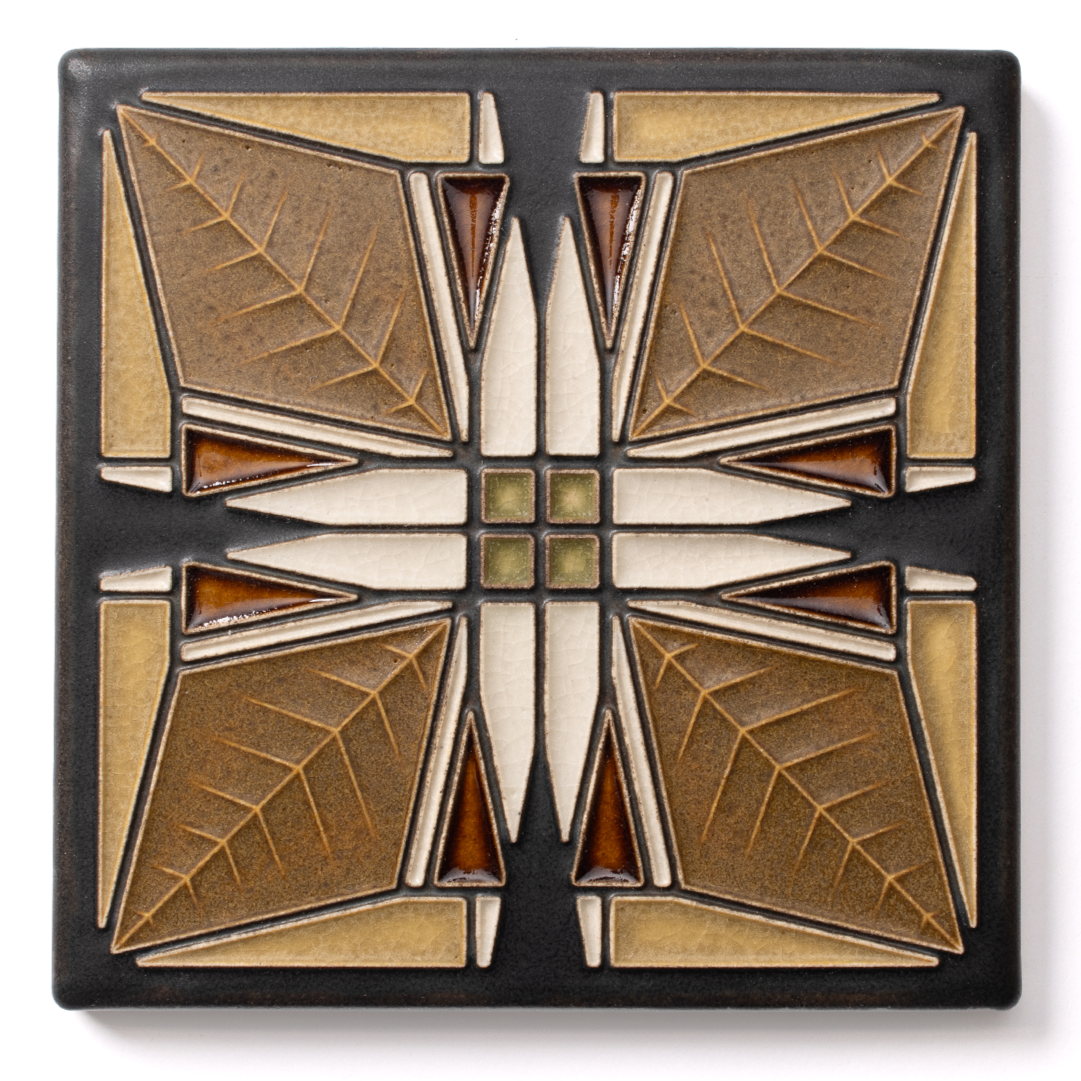 Decorative ceramic tile with geometric leaf pattern in brown, cream, black, and green colors.