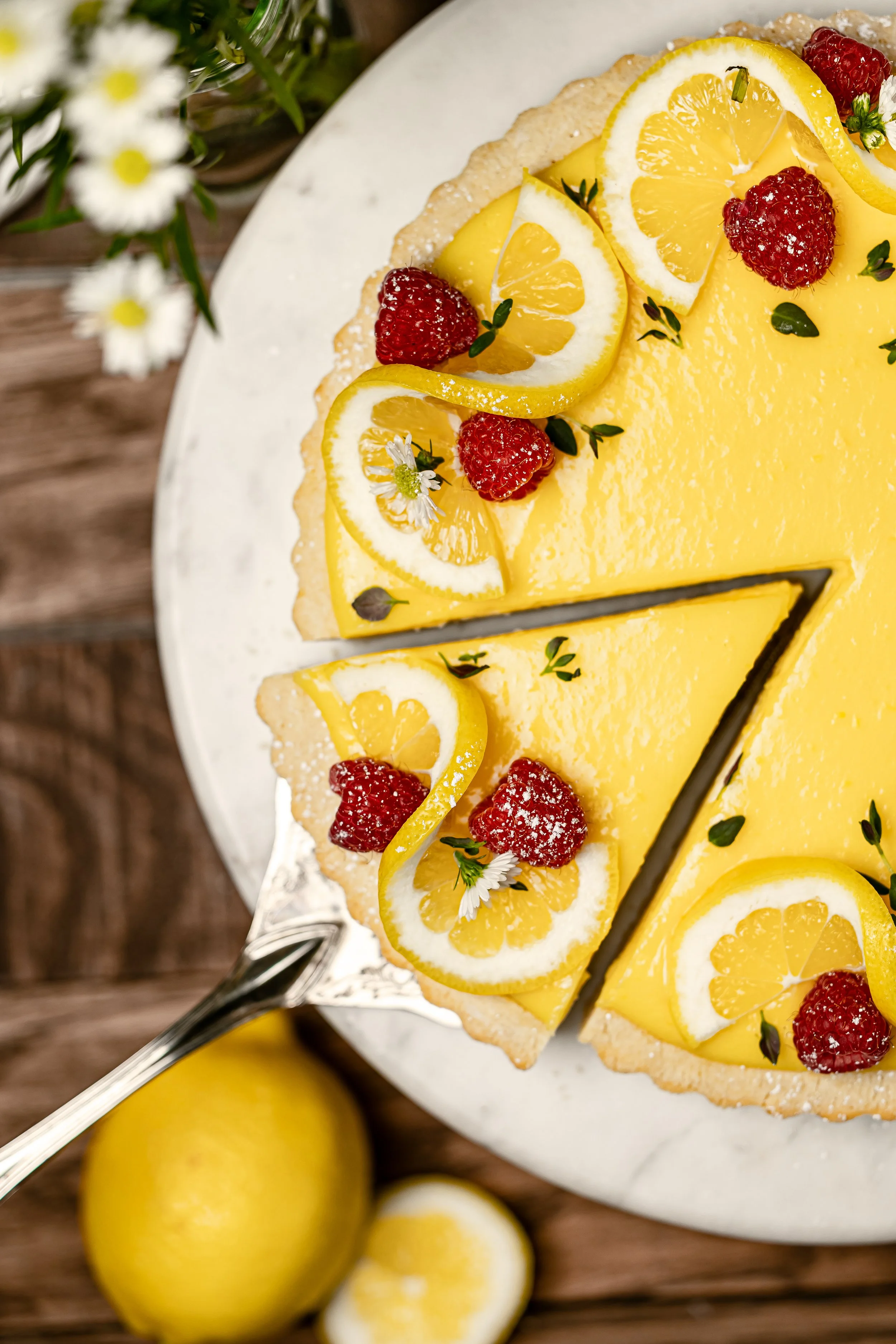 Serving of lemon curd tart with rasperries
