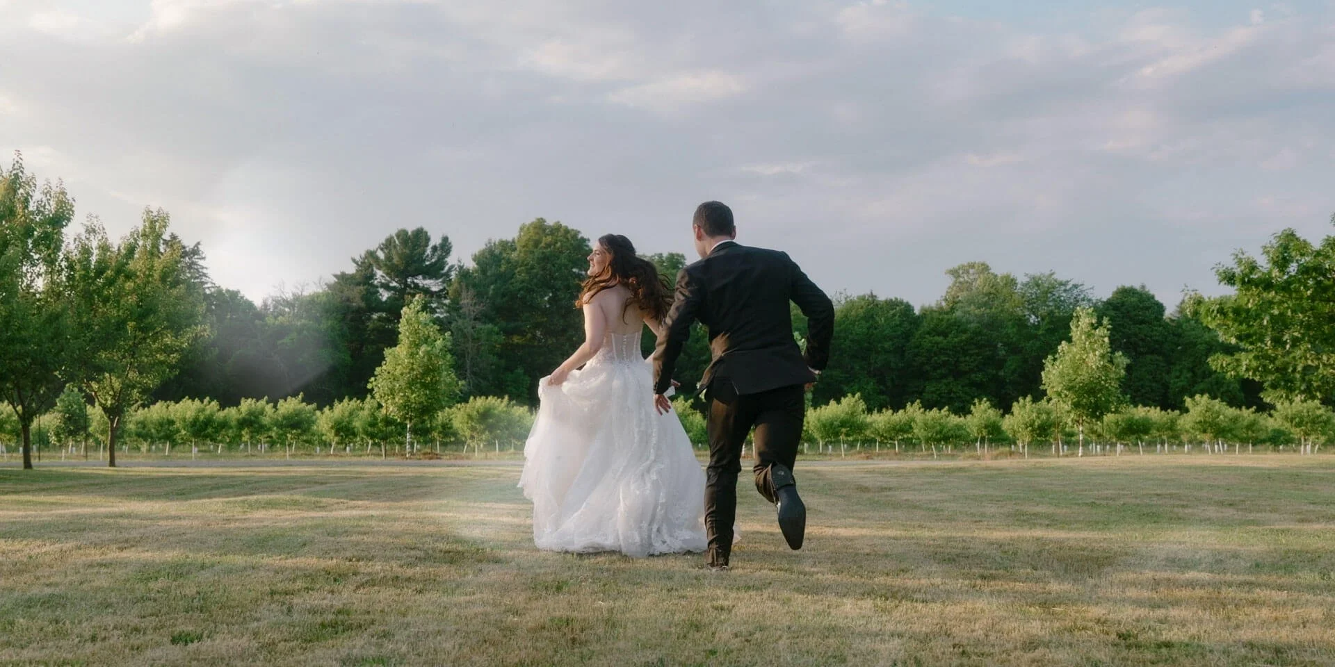 groom playfully chasing bride in her dress