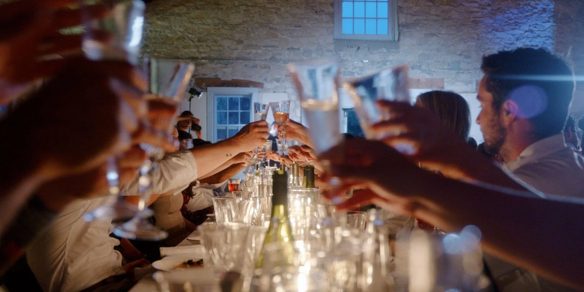 wedding guests clinking glasses across table