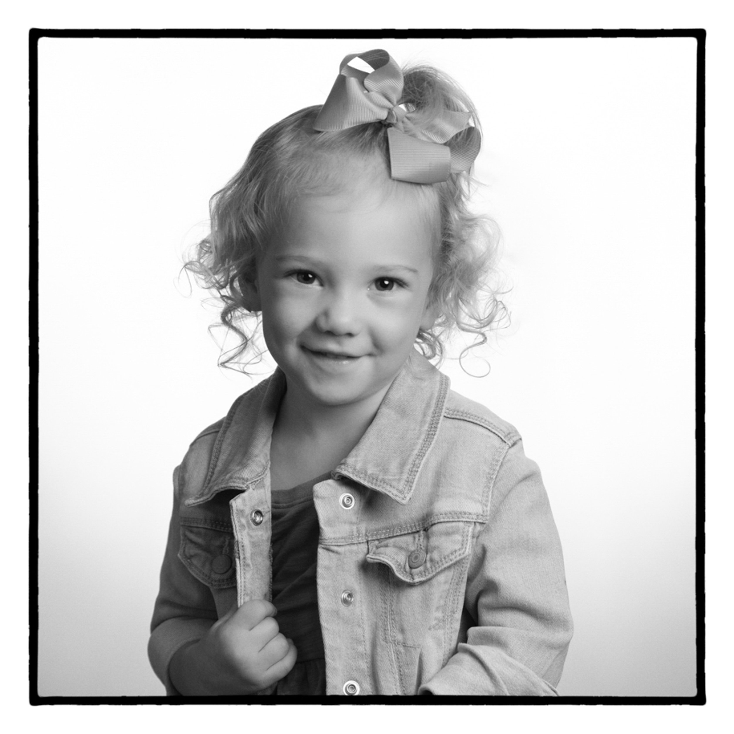 black and white portrait of young girl holding onto her jean jacket