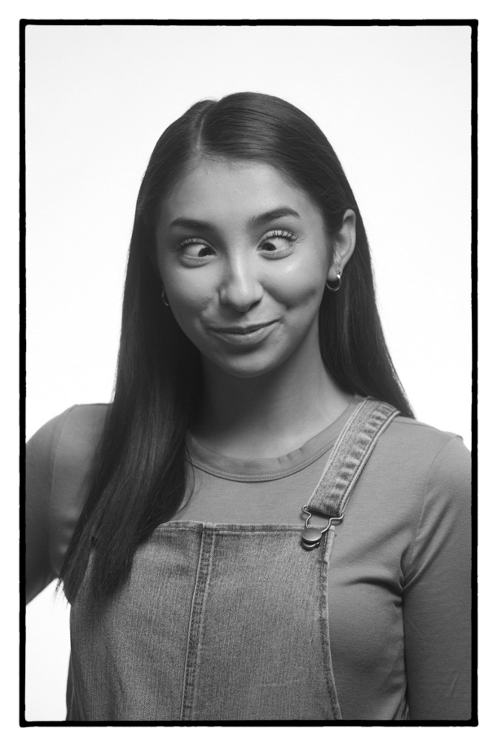 black and white portrait of young girl crossing her eyes and smiling