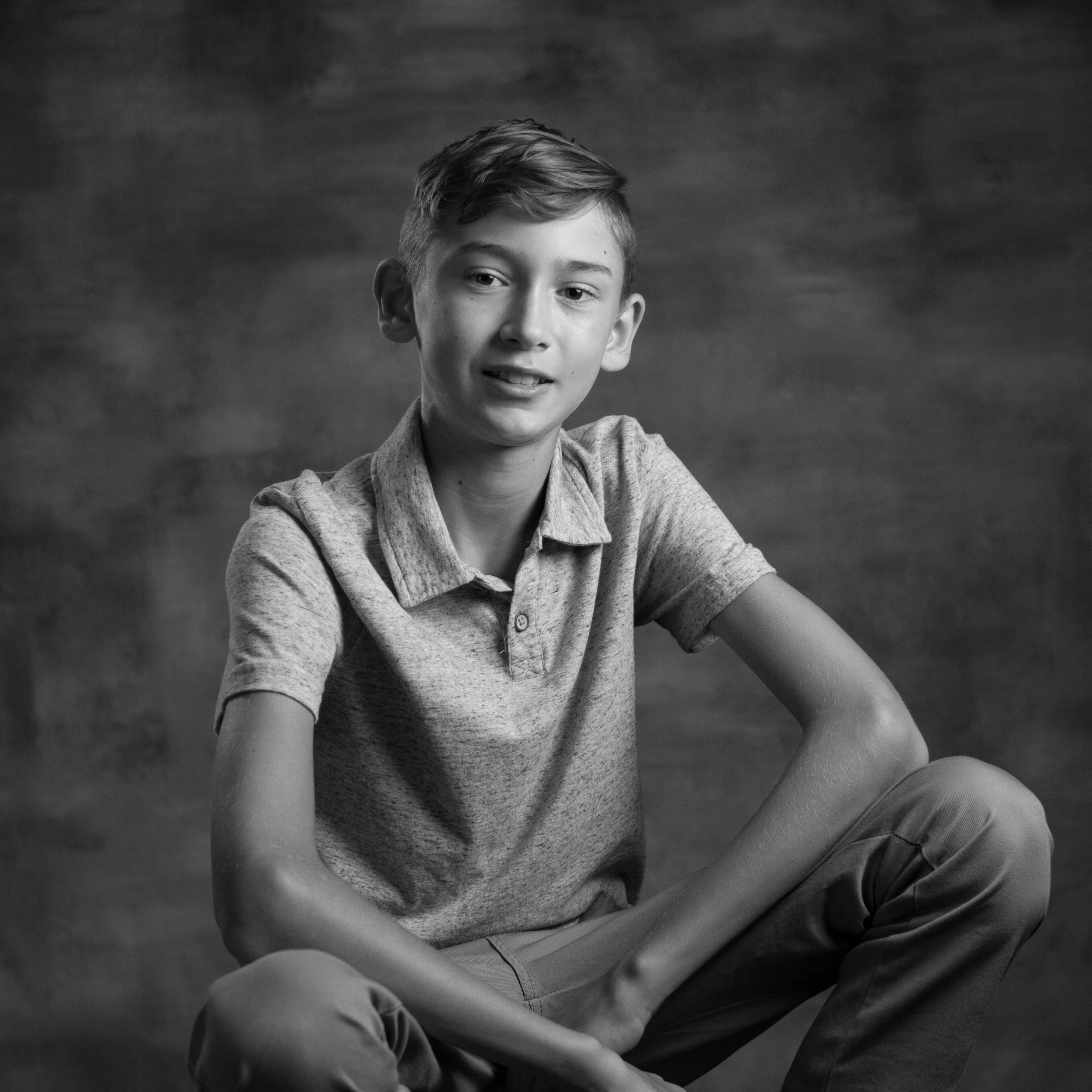black and white portrait of tween leaning in on his knees