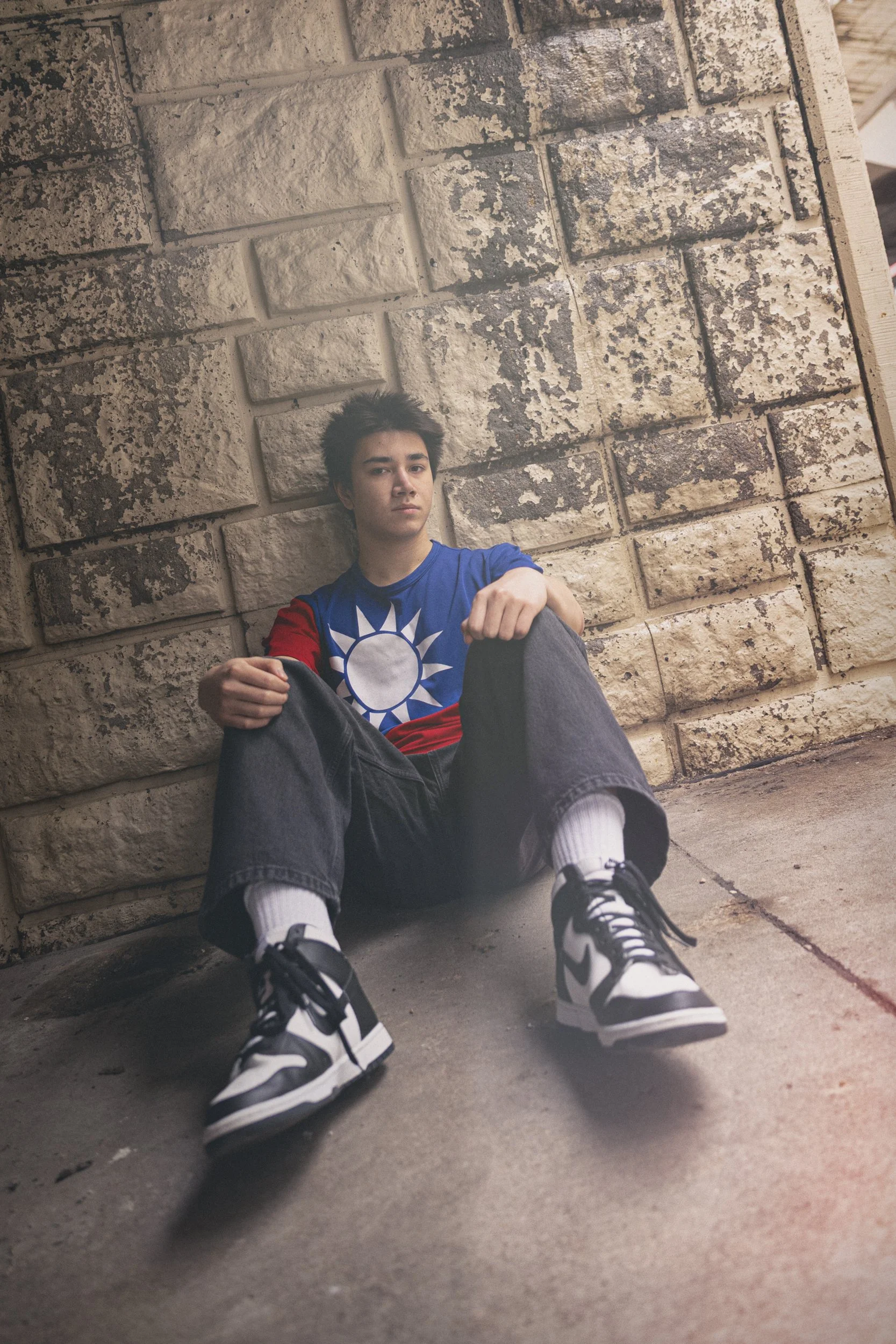 senior boy sitting under bridge