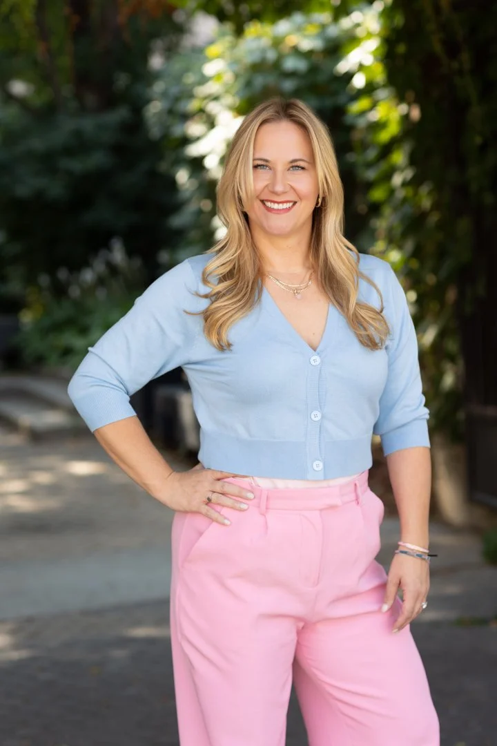 outdoor professional woman portrait in pink pants and blue blouse.