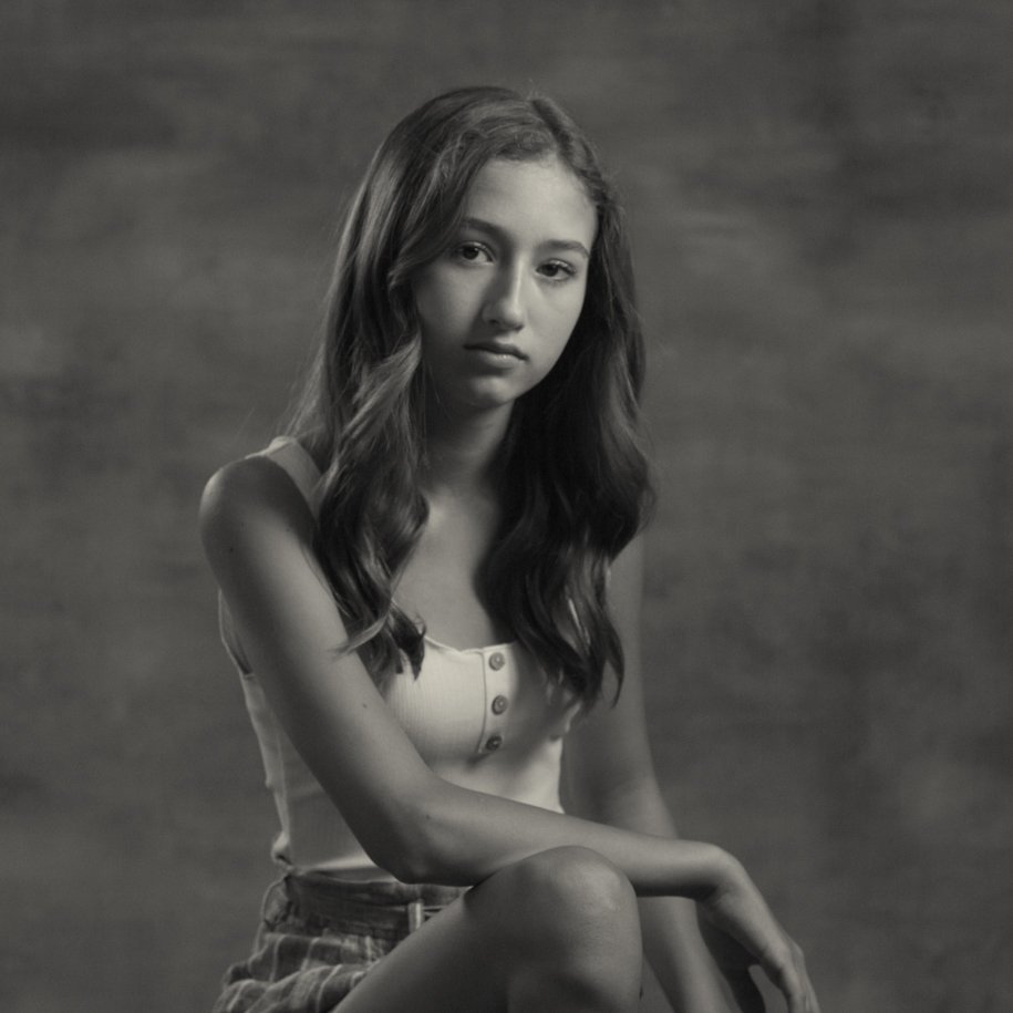 black and white portrait of young girl leaning in on her knee