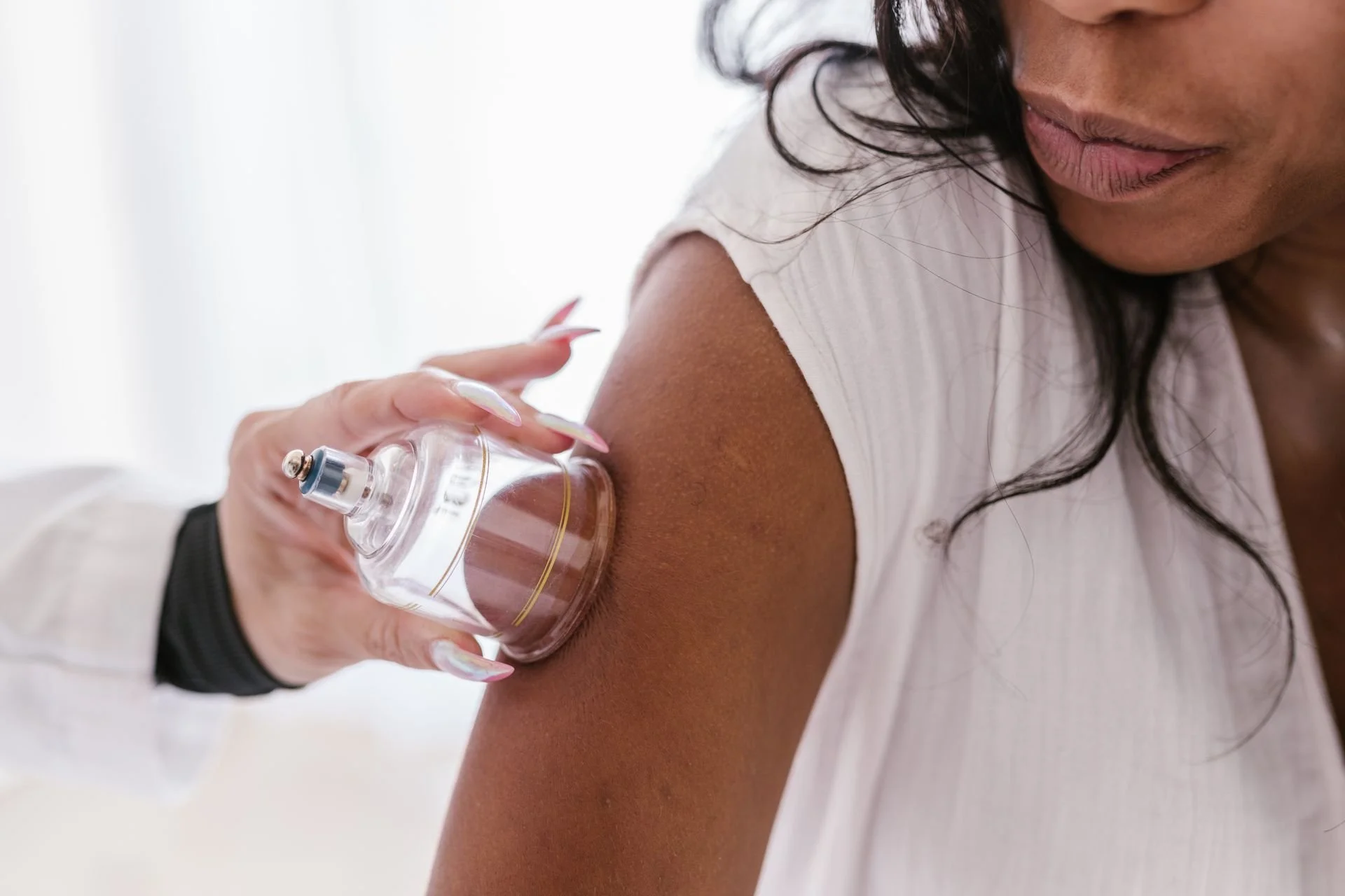 Practitioner placing a glass cupping cup on a patient's upper arm