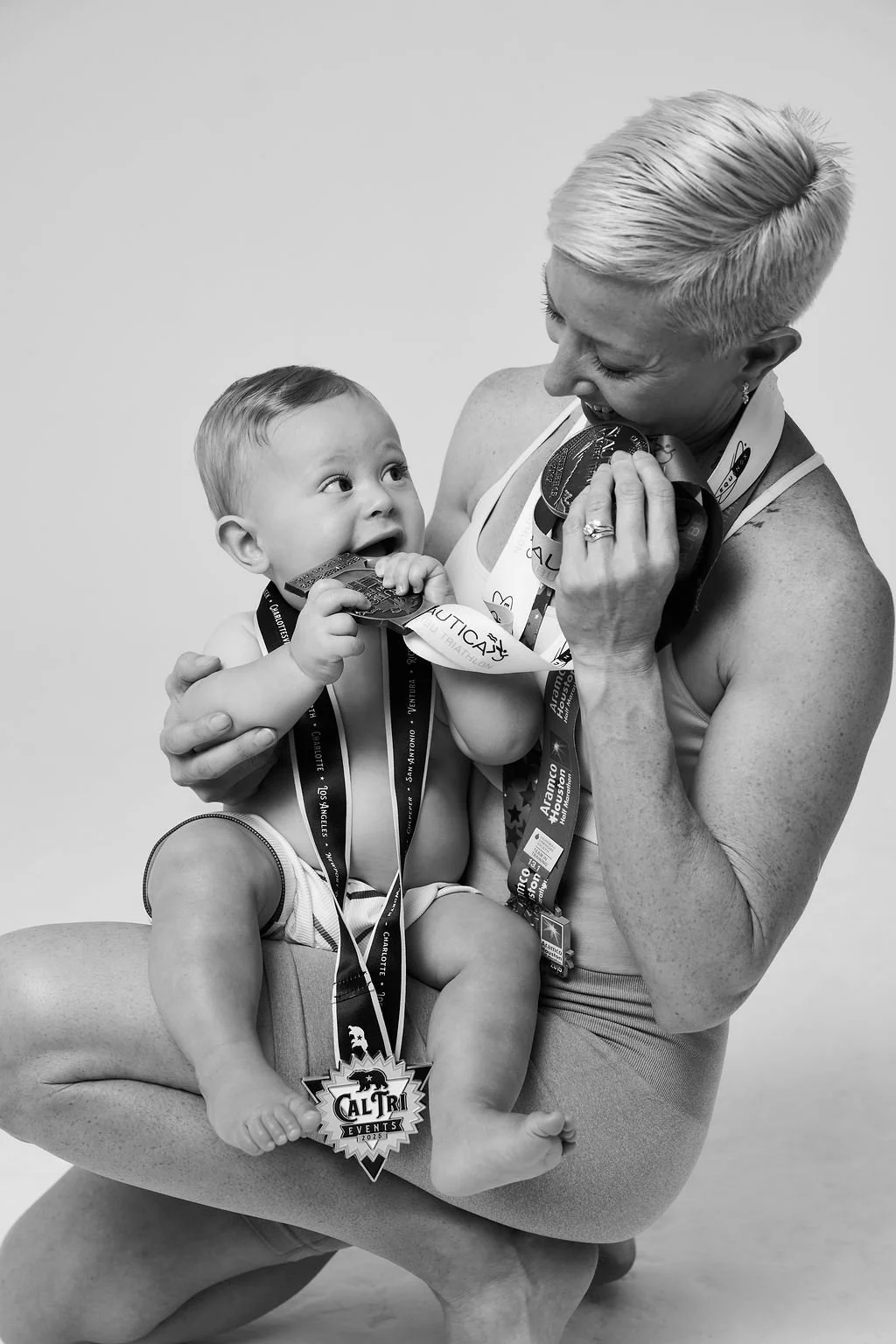 Rebekah Van Natta holding her baby son, who wears a finisher medal