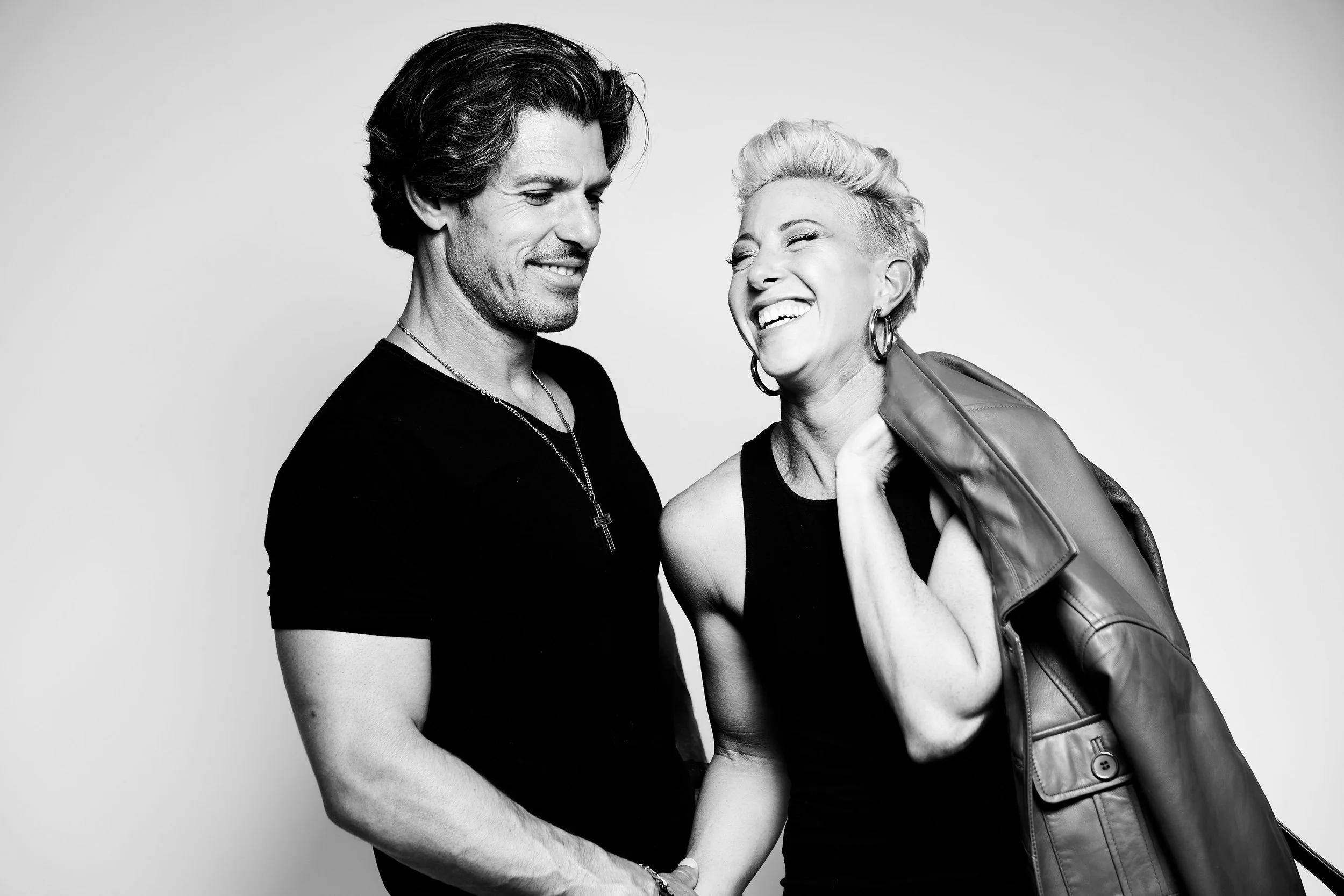 Rebekah Van Natta laughing with her husband in a black and white photo