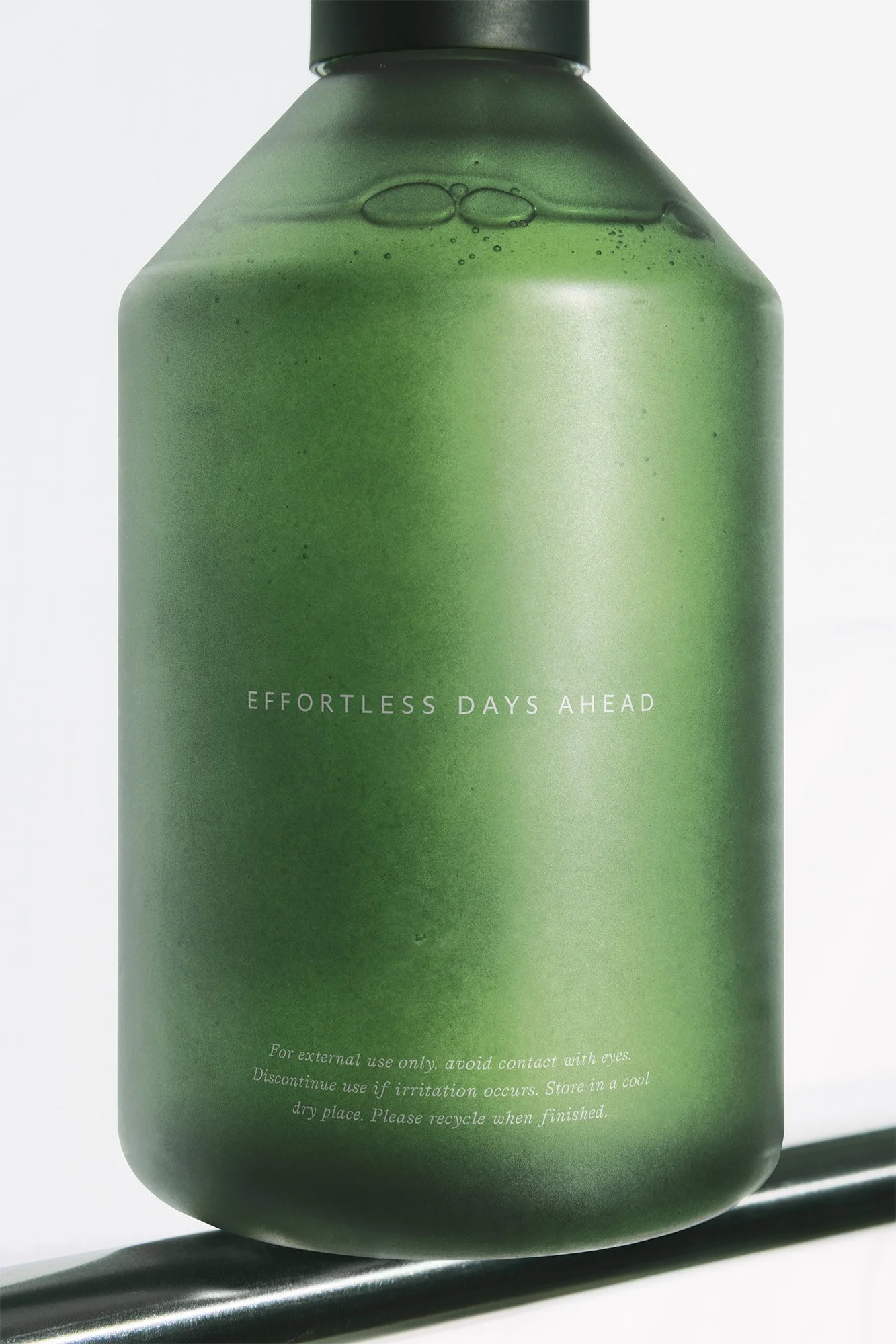 A green bottle with the words 'Effortless Days Ahead' printed on it and cautionary text below.