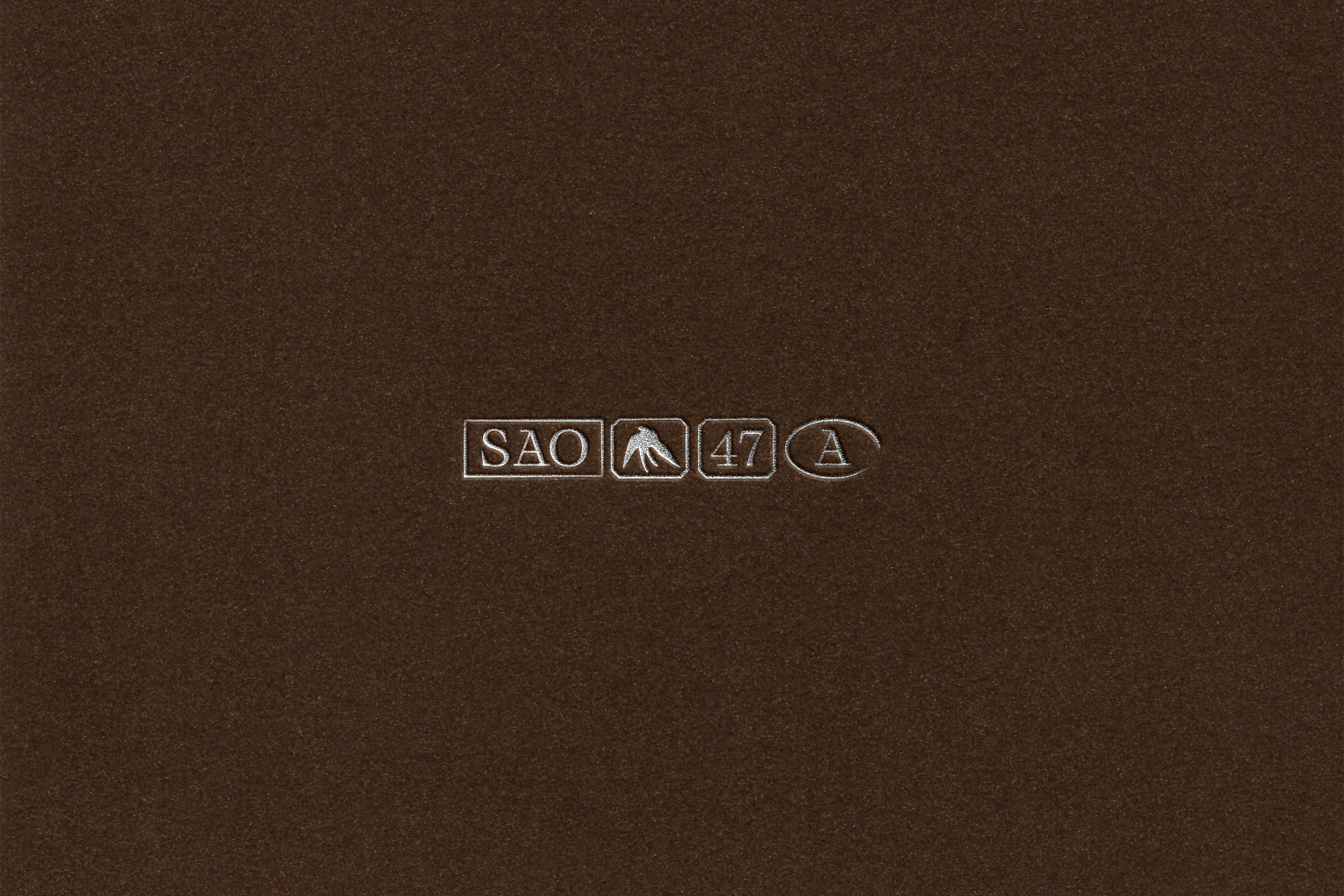 Close-up of a brown surface with embossed markings: 'SAO', a mountain symbol, '47', and an oval enclosing the letter 'A'.