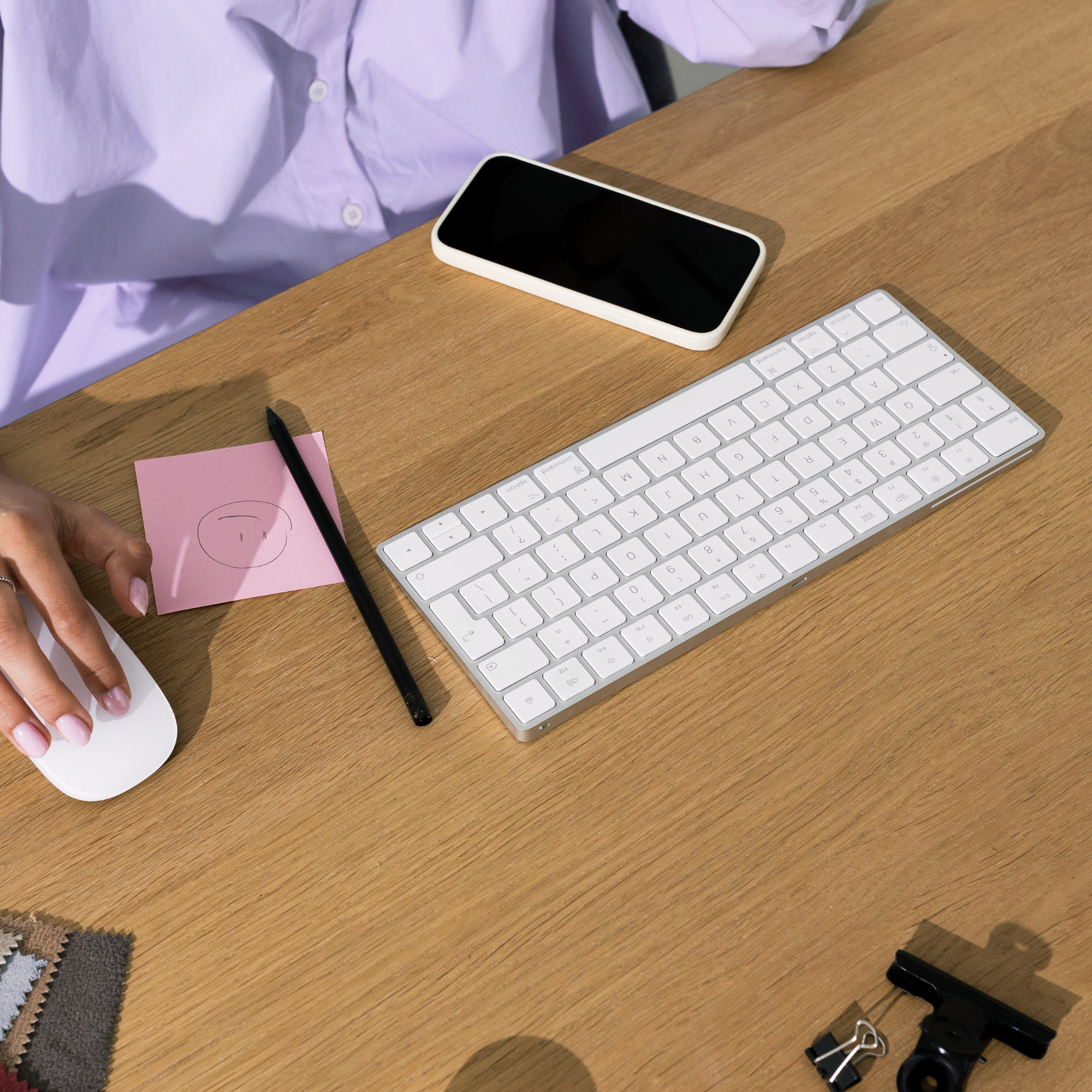 girl sitting at desk typing using mouse with phone nearby