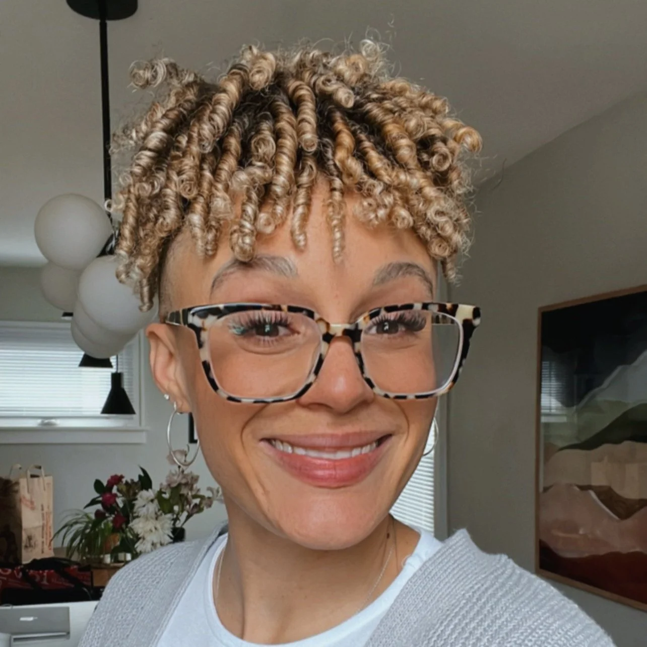 Olivia Small Registered Dietician with short curly hair and glasses smiling indoors.