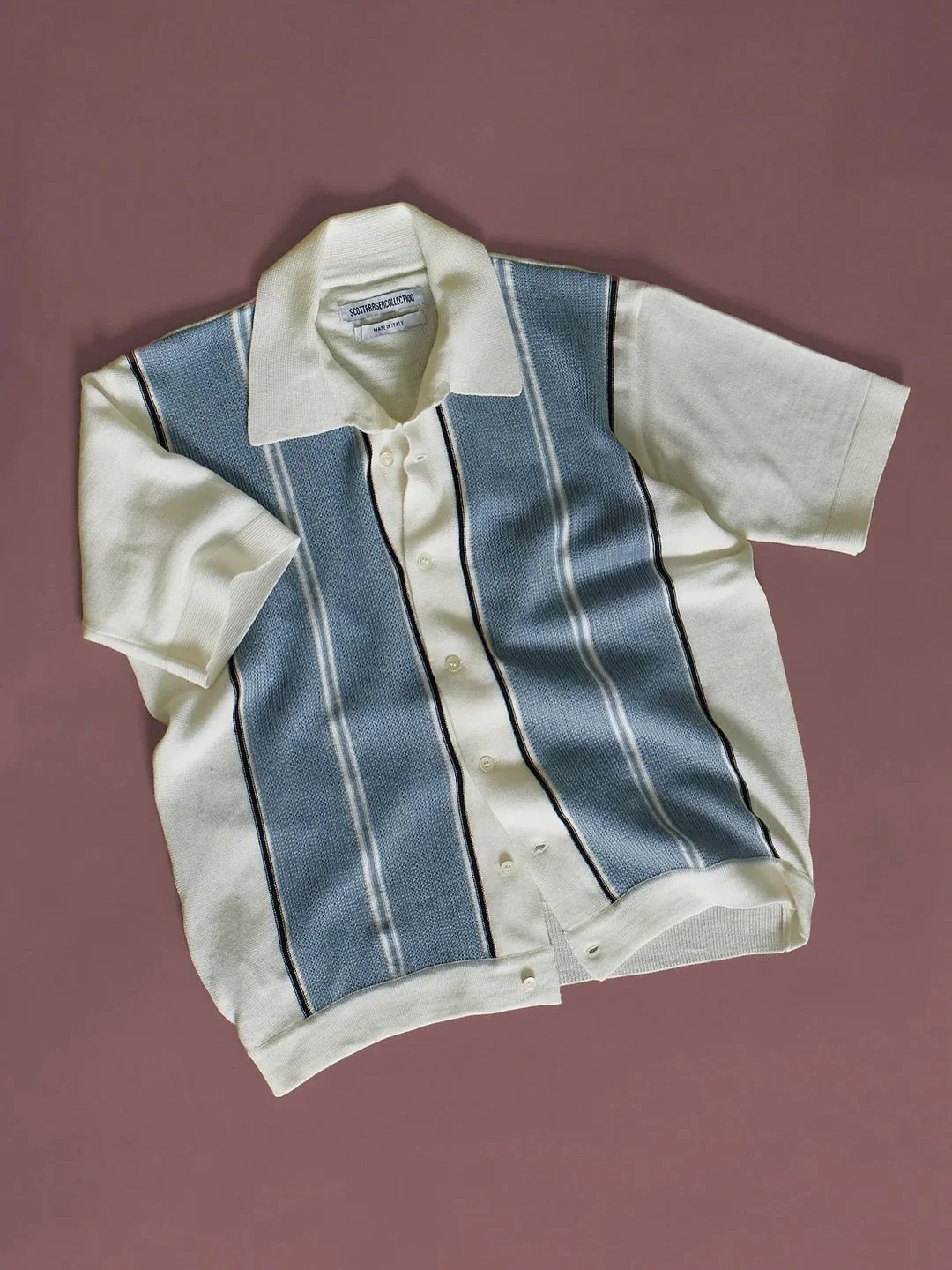 Scott Fraser The Talented Mr Ripley (1999); knit. Available in store.

Made in Milan, Italy, using a fine-gauge 100% Merino wool the crisp white body has blue/grey textured front panels which are set between strong striped details.
Every detail, weav