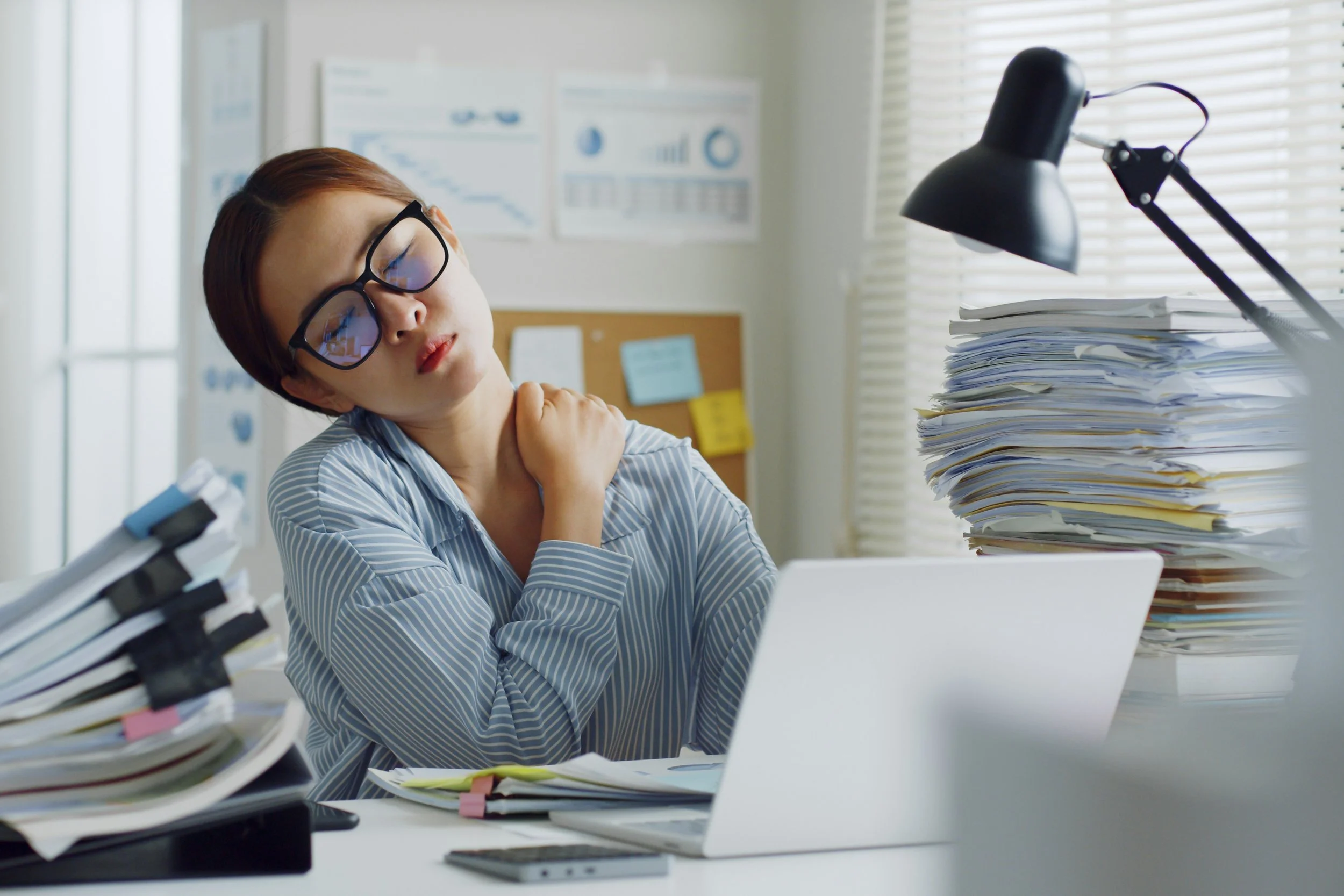 Therapist sitting at a desk thoughtfully reviewing notes and making clinical decisions.