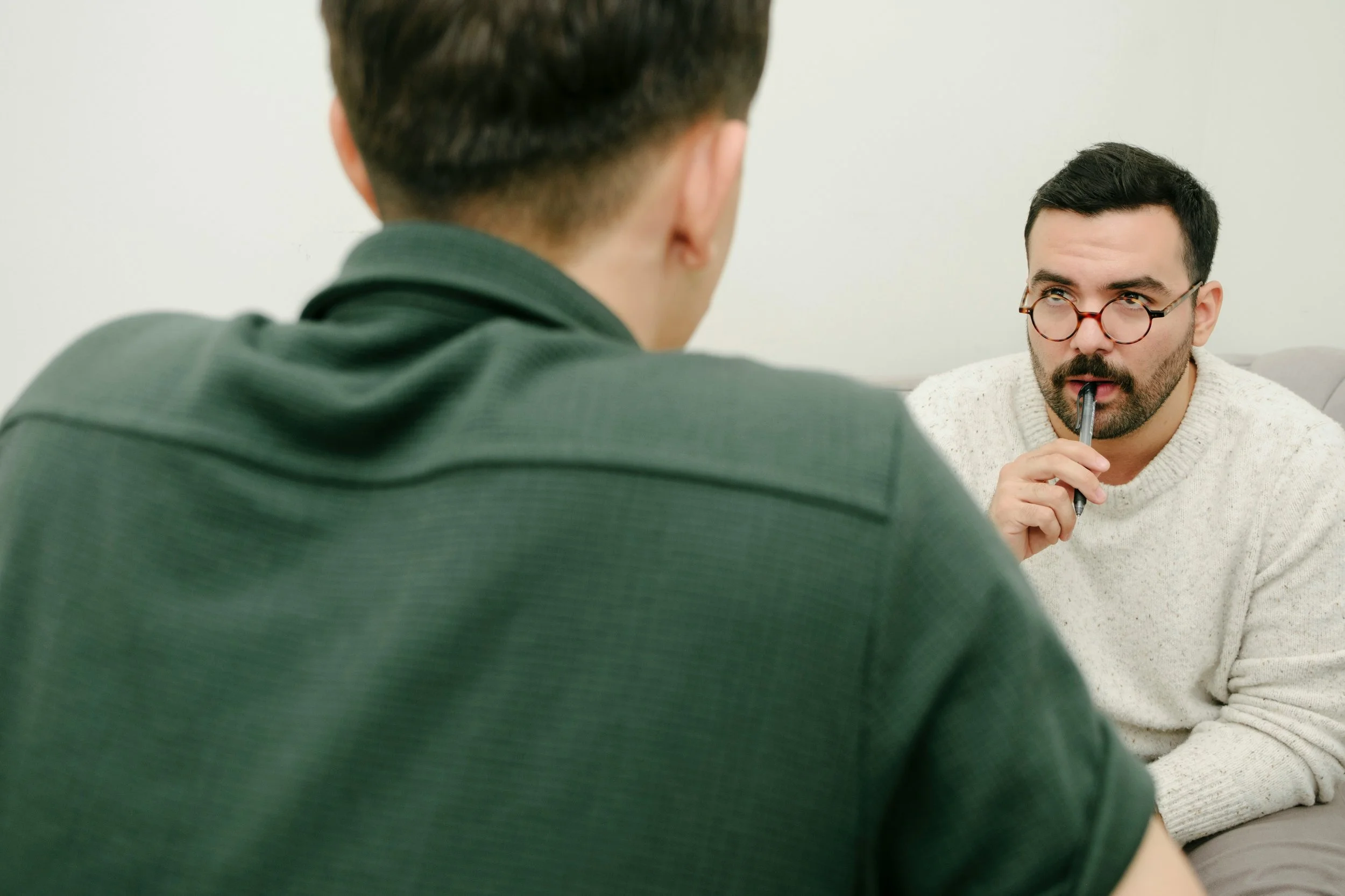 Therapist listening to a thoughtful client during a counseling session, representing the difference between emotional insight and intellectualization in therapy