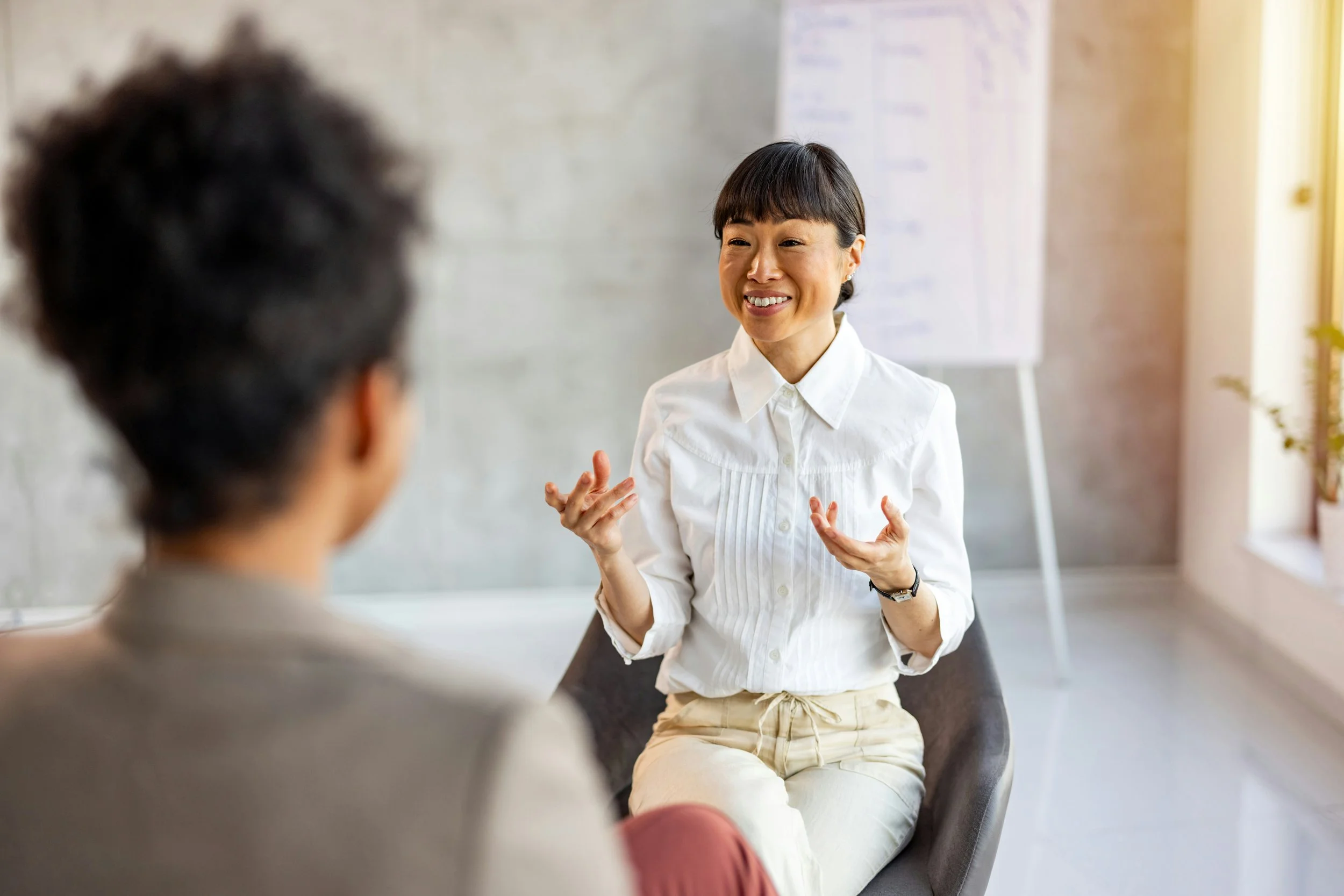 Therapist and client having a conversation in an office, representing the collaborative nature of the therapeutic relationship.