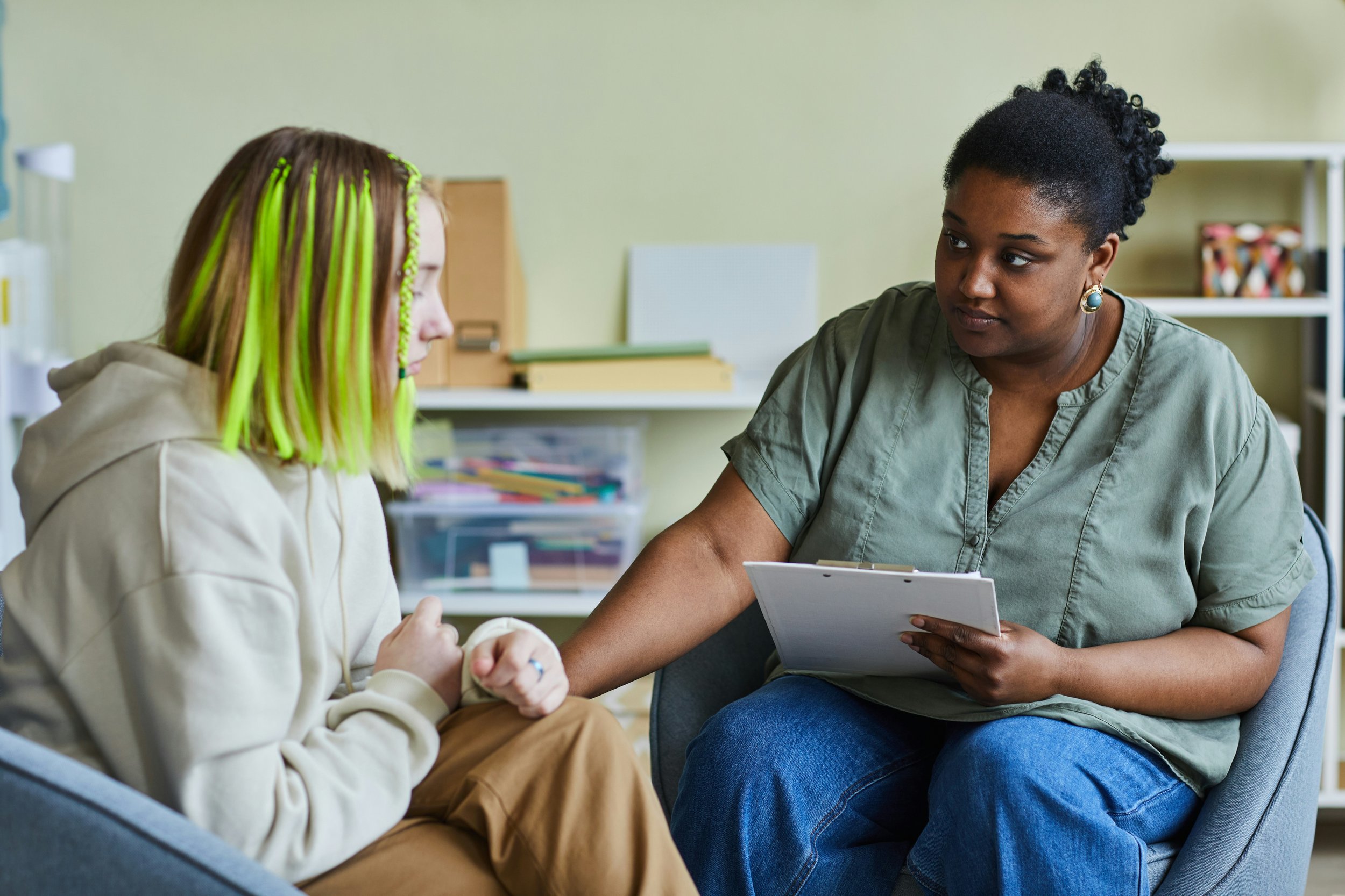 Therapist listening thoughtfully to a client during a counseling session.