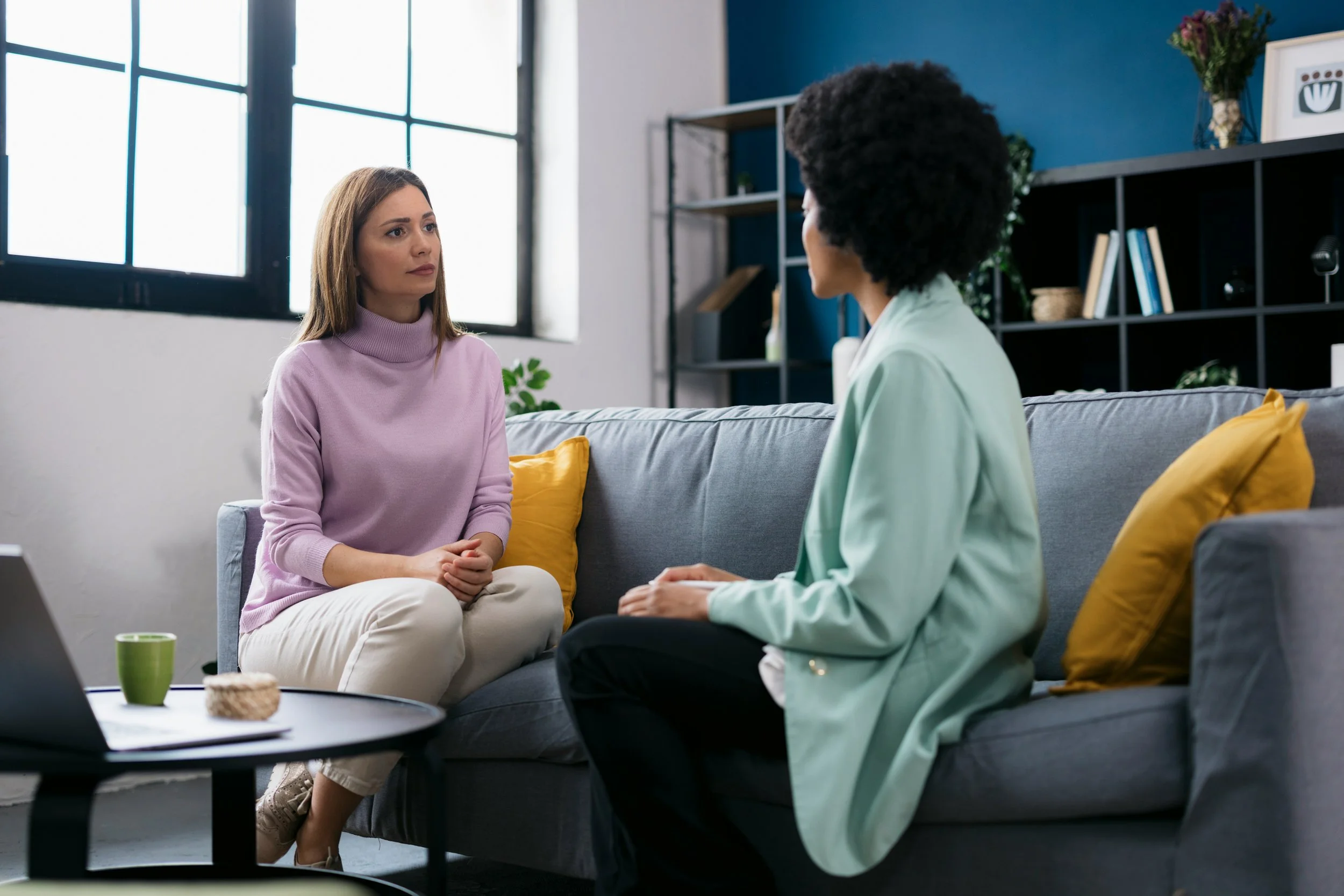 Therapist and client engaged in a calm conversation in a counseling office, representing therapeutic rupture and repair and the development of clinical skills.