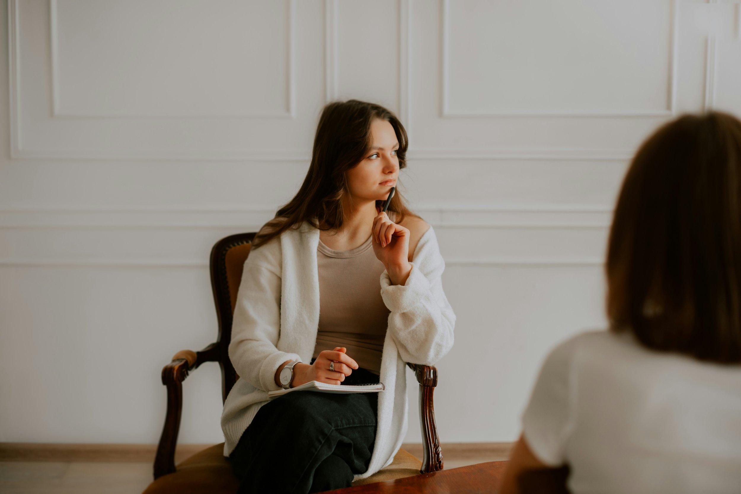 Therapist sitting thoughtfully in an office after a session, representing the self-reflection involved in navigating difficult therapeutic relationships.