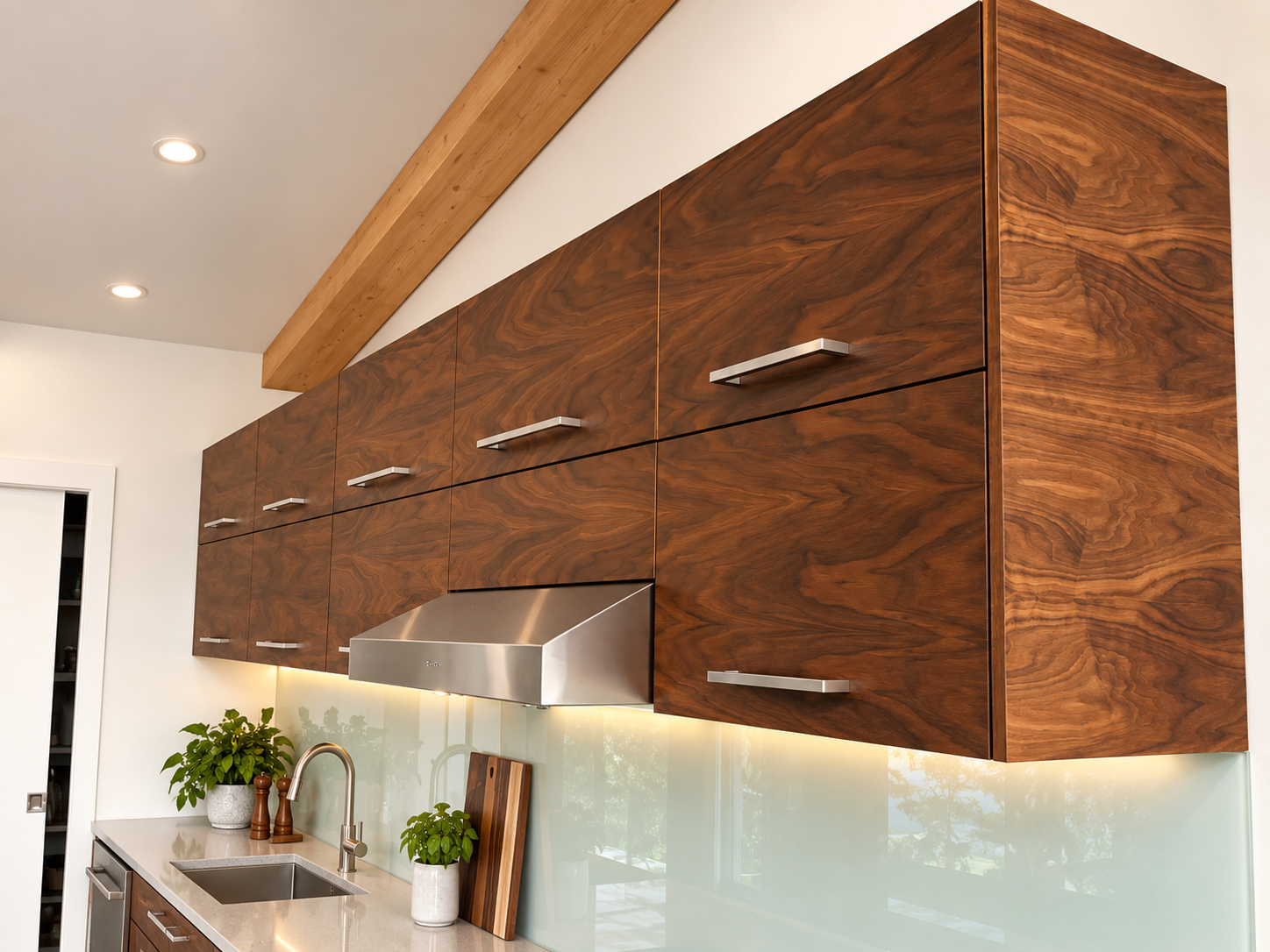 Close-up of custom walnut kitchen cabinetry with deep drawers, integrated appliances and natural wood grain.